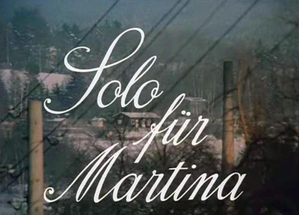 Schriftzug "Solo für Martina" über einer verschneiten Landschaft mit Häusern.