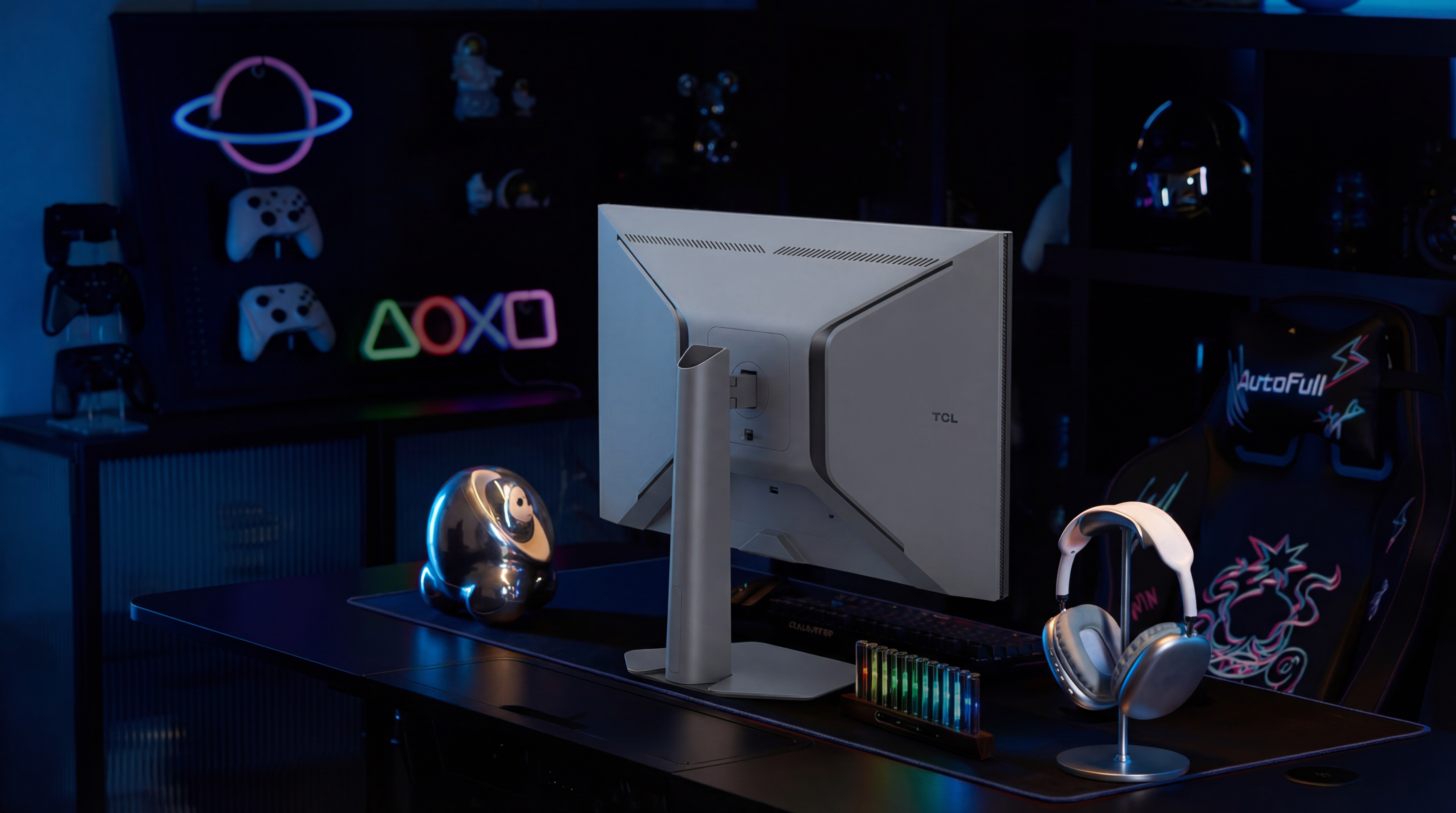 Ein Gaming-Setup mit einem Monitor, Kopfhörern und Neonlichtern.