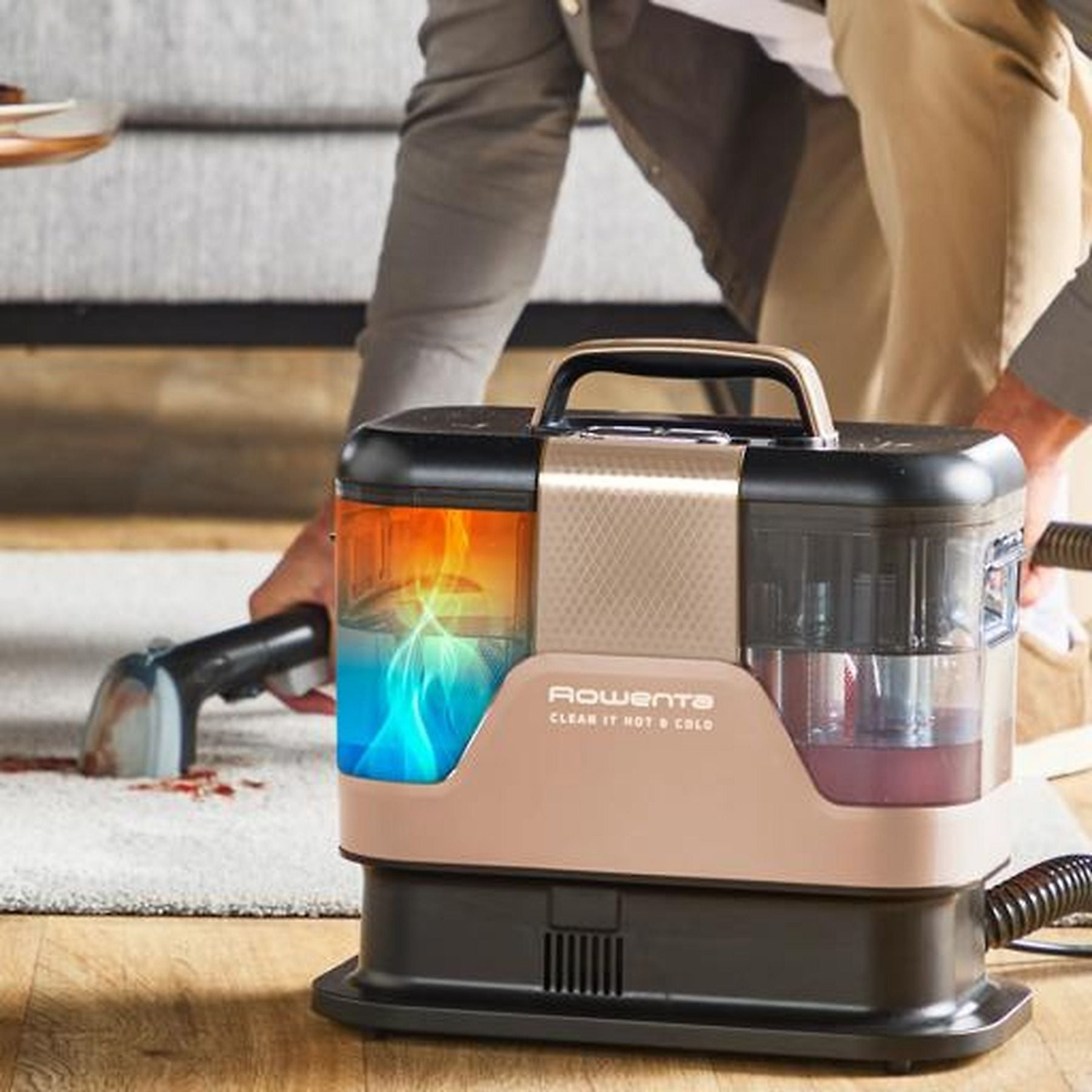 A cleaning device with a hose cleans a stained carpet.