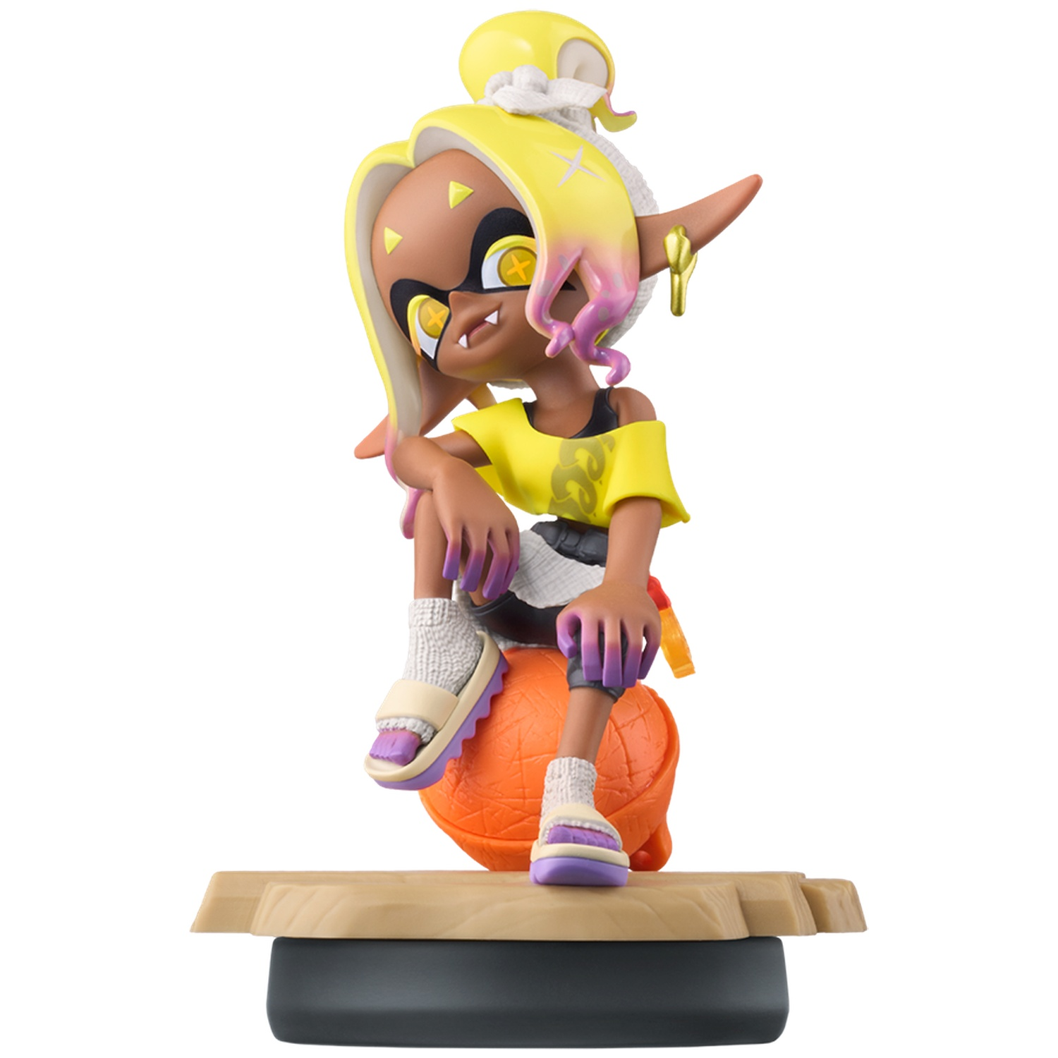 A yellow-haired figurine with purple tips sits on an orange ball. It wears a yellow shirt and shorts.