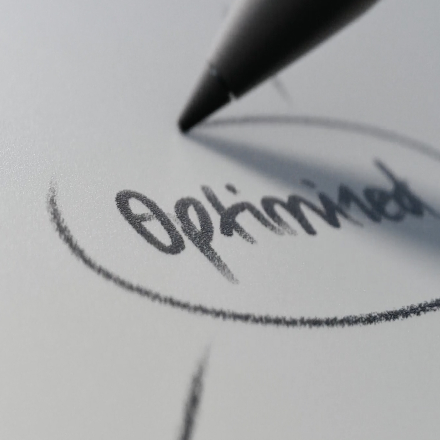 A stylus writes the word Optimized in a circle on a white surface.