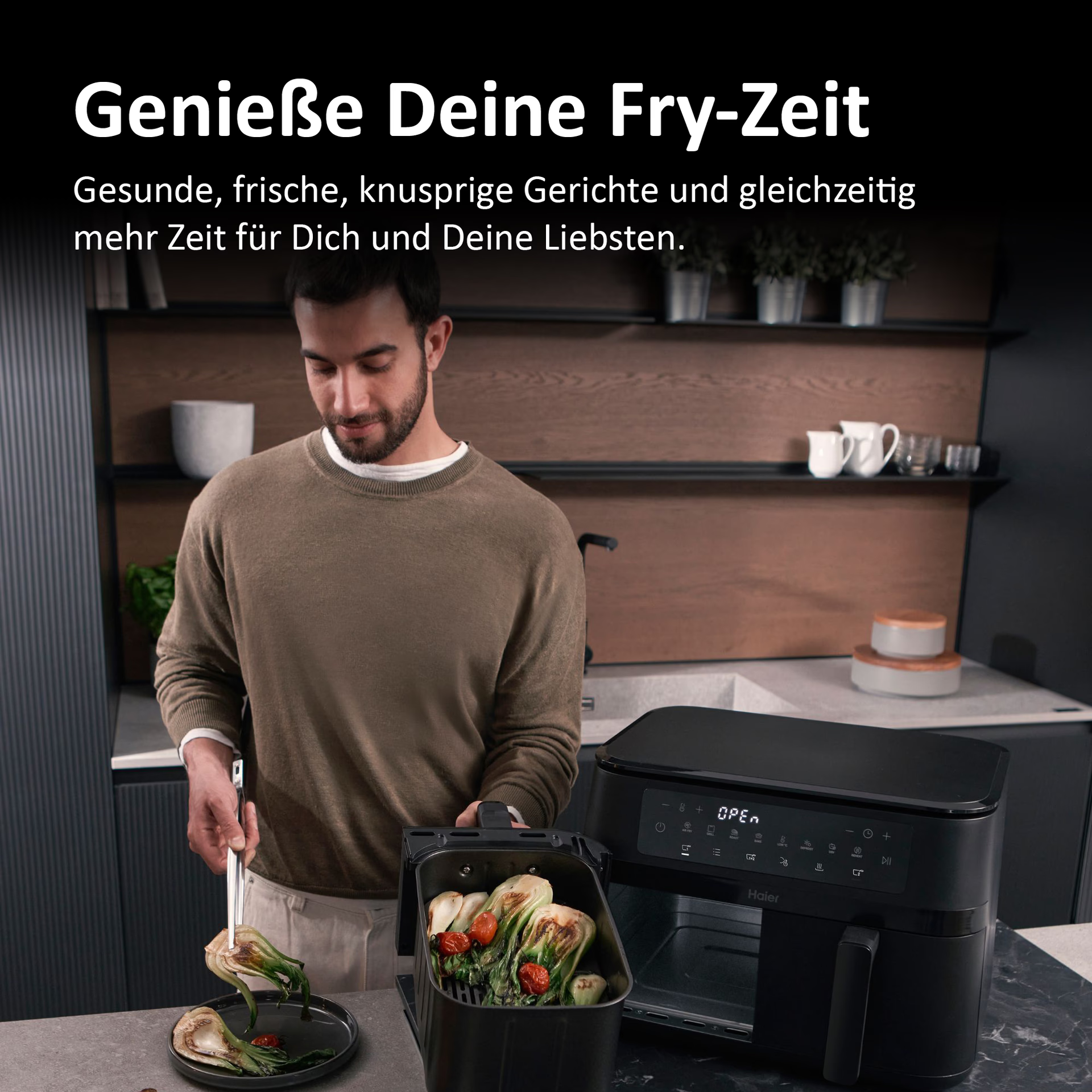 Mann nimmt gebratenes Gemüse aus Heißluftfritteuse in einer Küche.