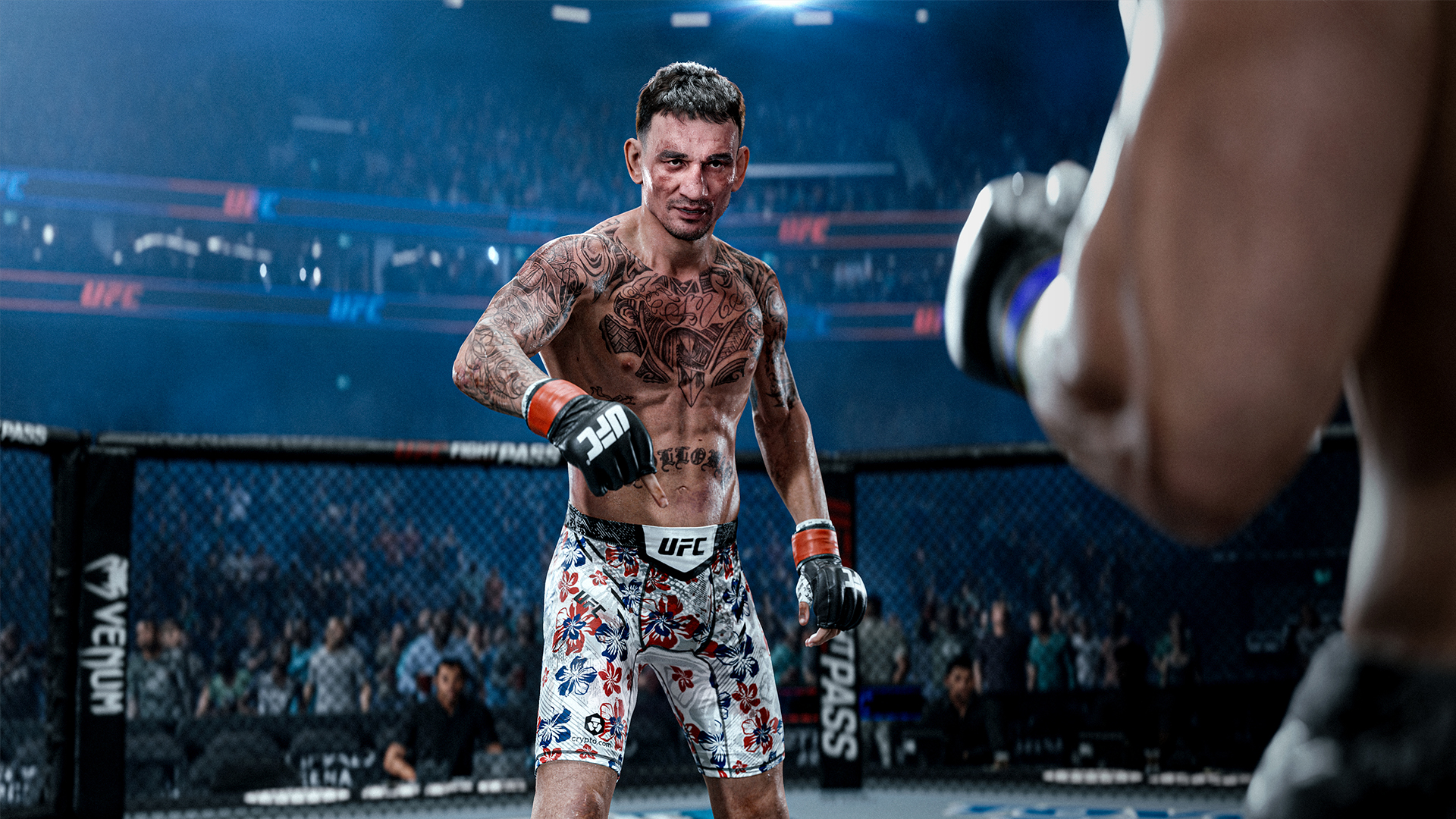 Un hombre tatuado está en un ring de UFC, vistiendo pantalones cortos coloridos y guantes.