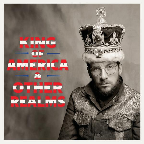 Koronát és szemüveget viselő férfi, zakóban. "King of America & Other Realms" felirat.