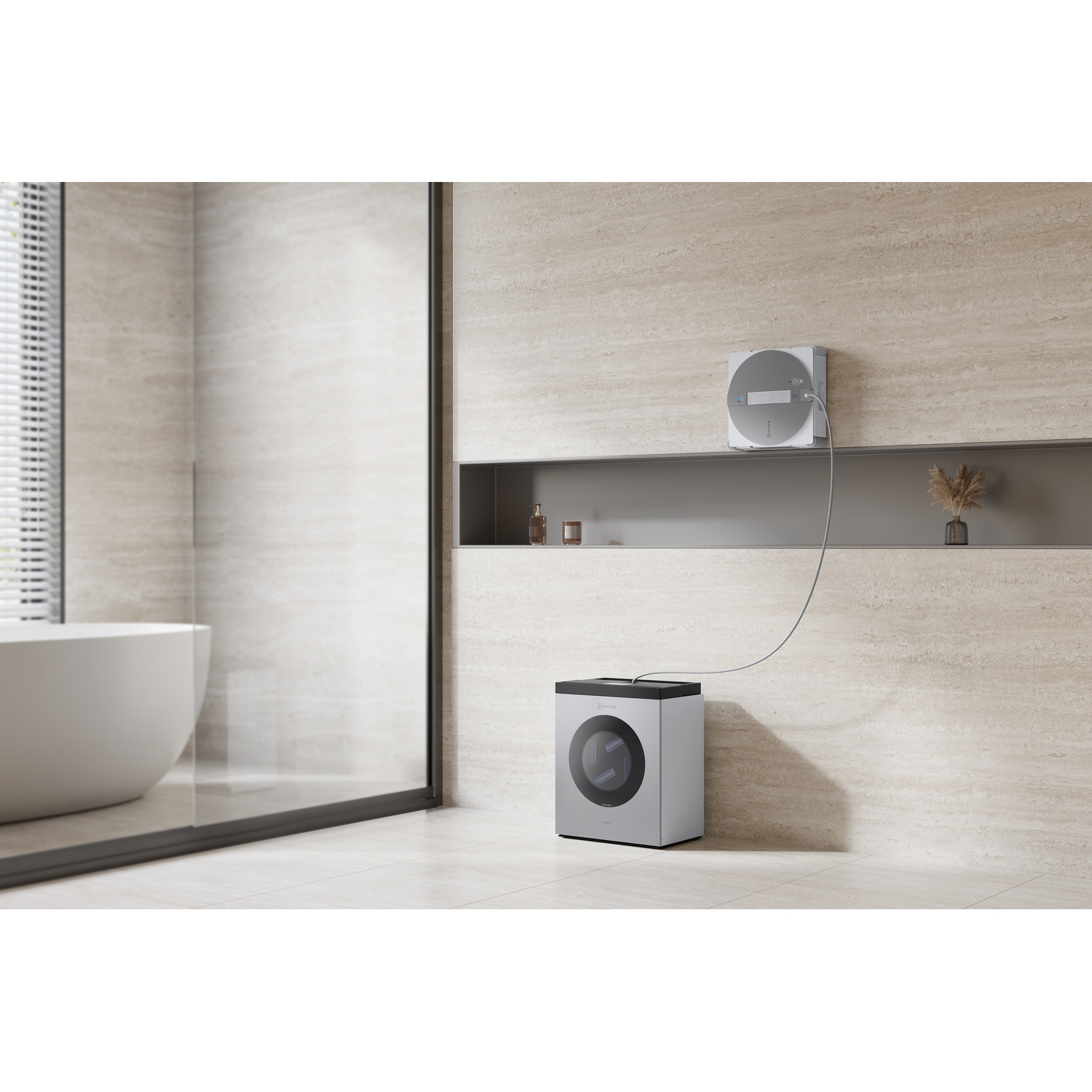 Una piccola asciugatrice argentata si trova in un bagno moderno accanto a una vasca da bagno.