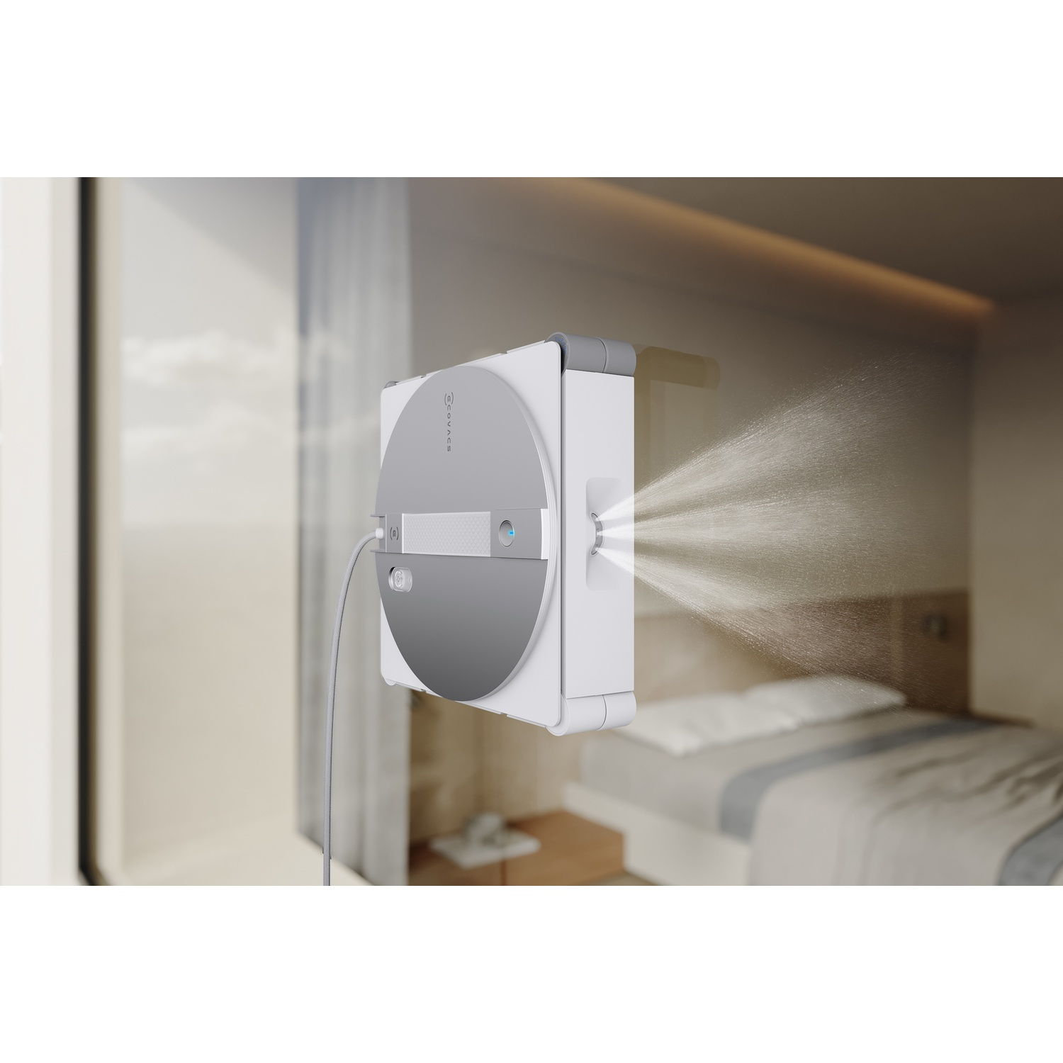Un robot bianco lava-finestre spruzza acqua su una finestra davanti a una camera da letto.