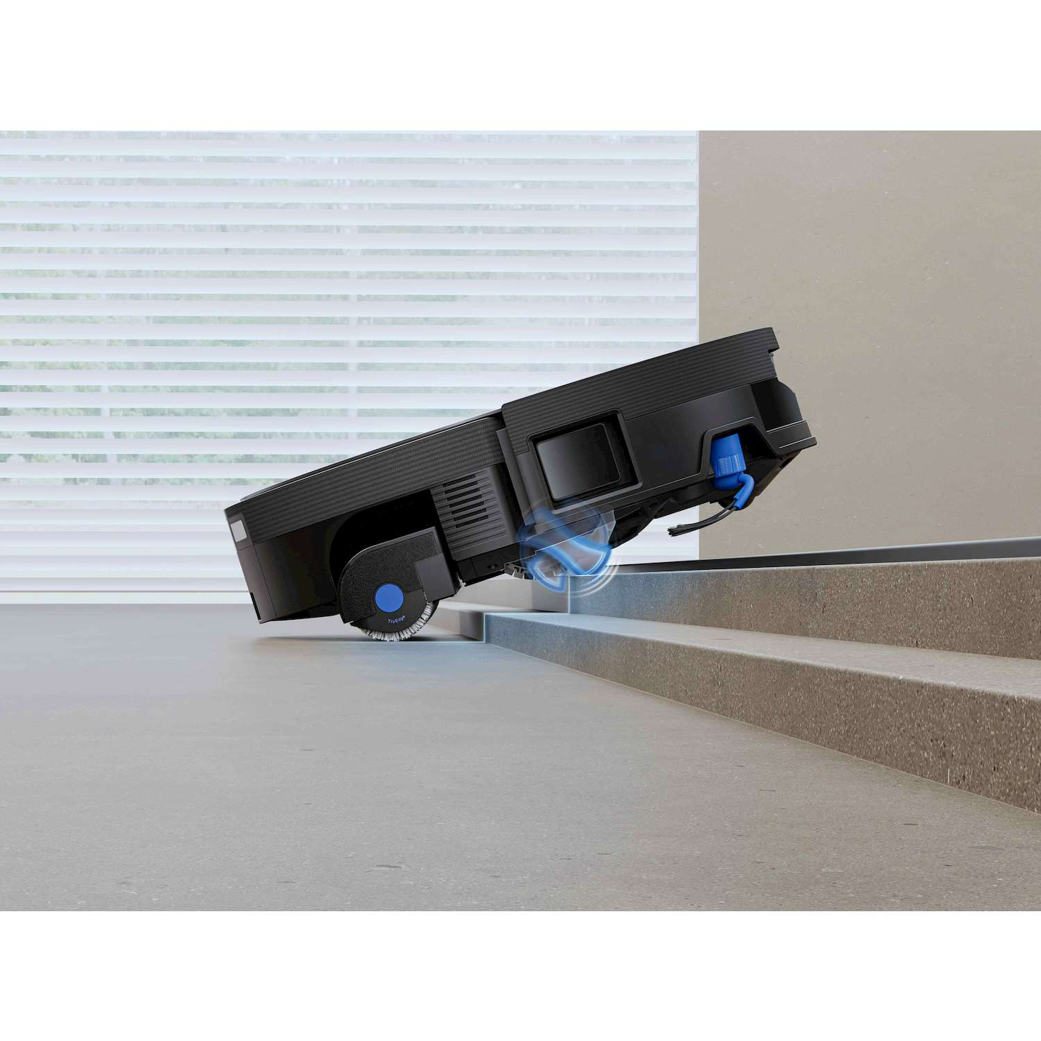 Un robot aspirapolvere nero naviga vicino al bordo delle scale per evitare una caduta.