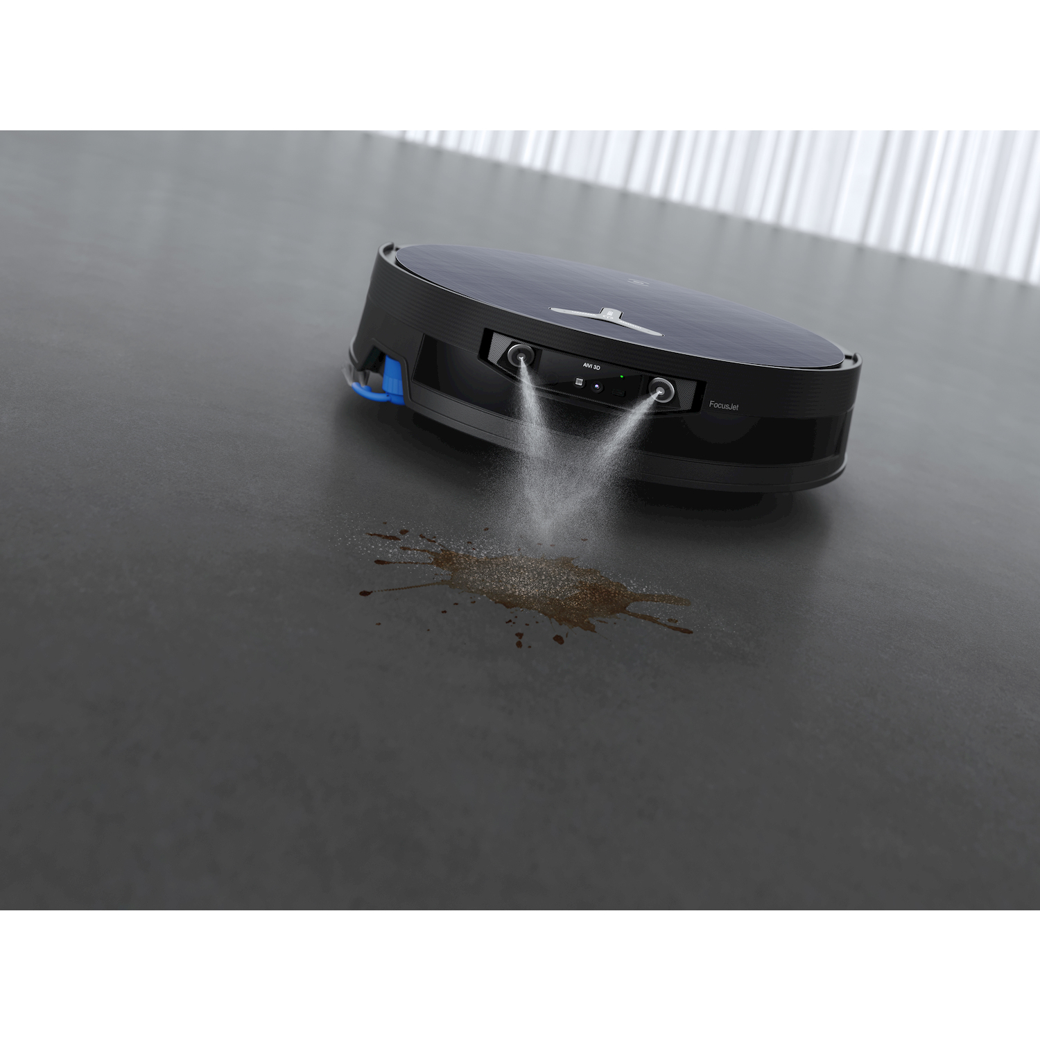 Un robot aspirapolvere nero spruzza acqua su una macchia sporca su un pavimento grigio.