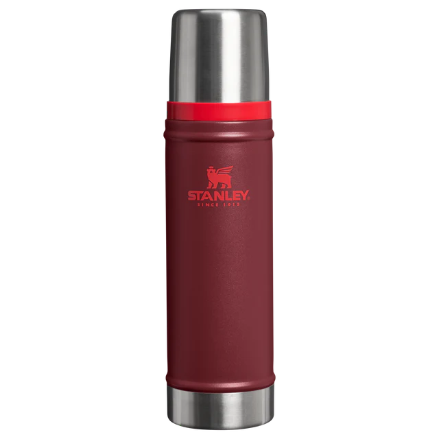 Gümüş kapaklı ve kırmızı bantlı, koyu kırmızı Stanley termos.
