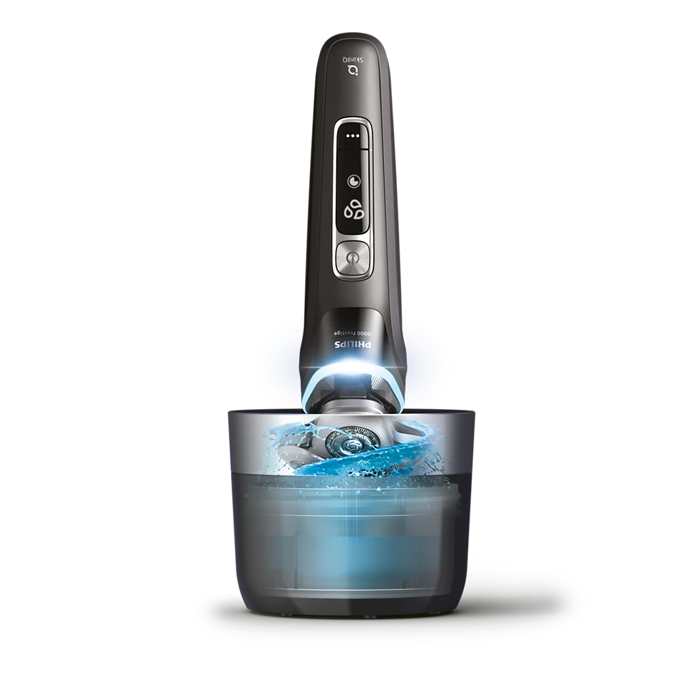 Ein dunkler Elektrorasierer mit blauem Licht steht über einer Schale mit sprudelndem Wasser.