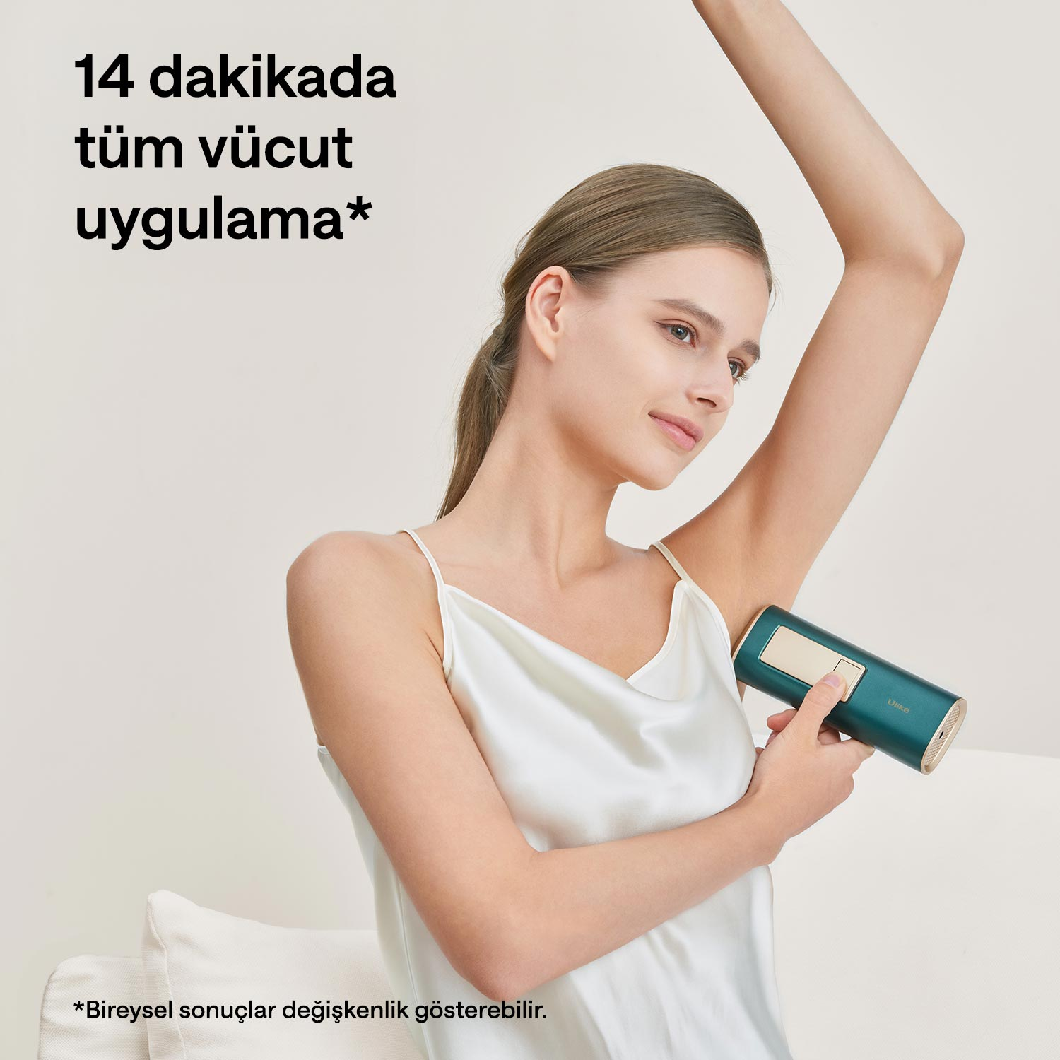 Beyaz üstlü kadın kolunda yeşil epilasyon cihazı kullanıyor.