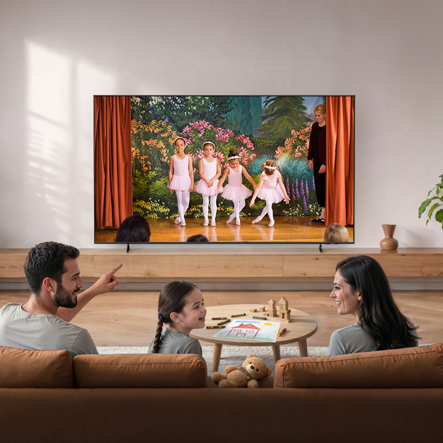 Una famiglia guarda ballerine di balletto in TV seduta sul divano.