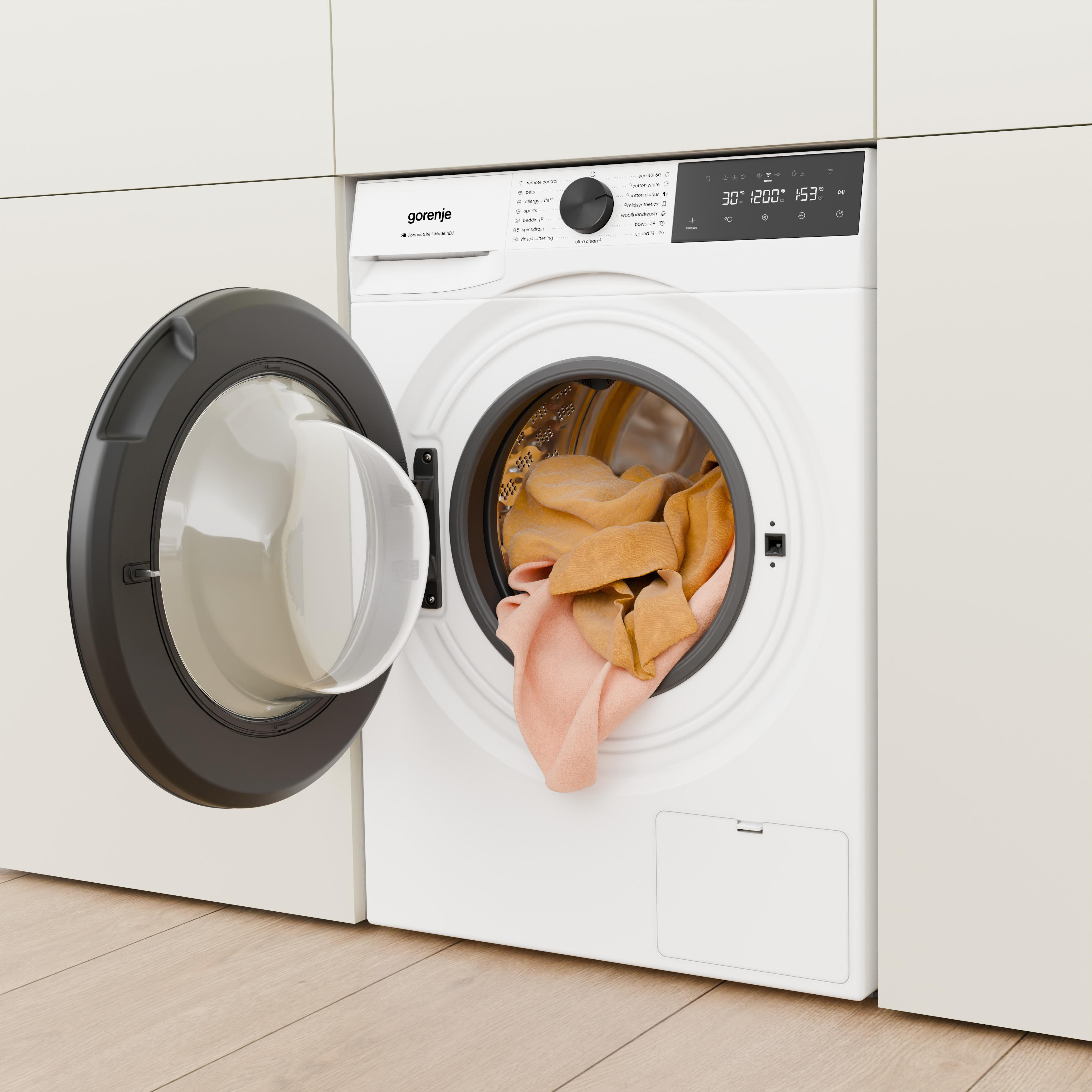 Eine weiße Gorenje-Waschmaschine mit geöffneter Tür und darin liegender orangefarbener Wäsche.