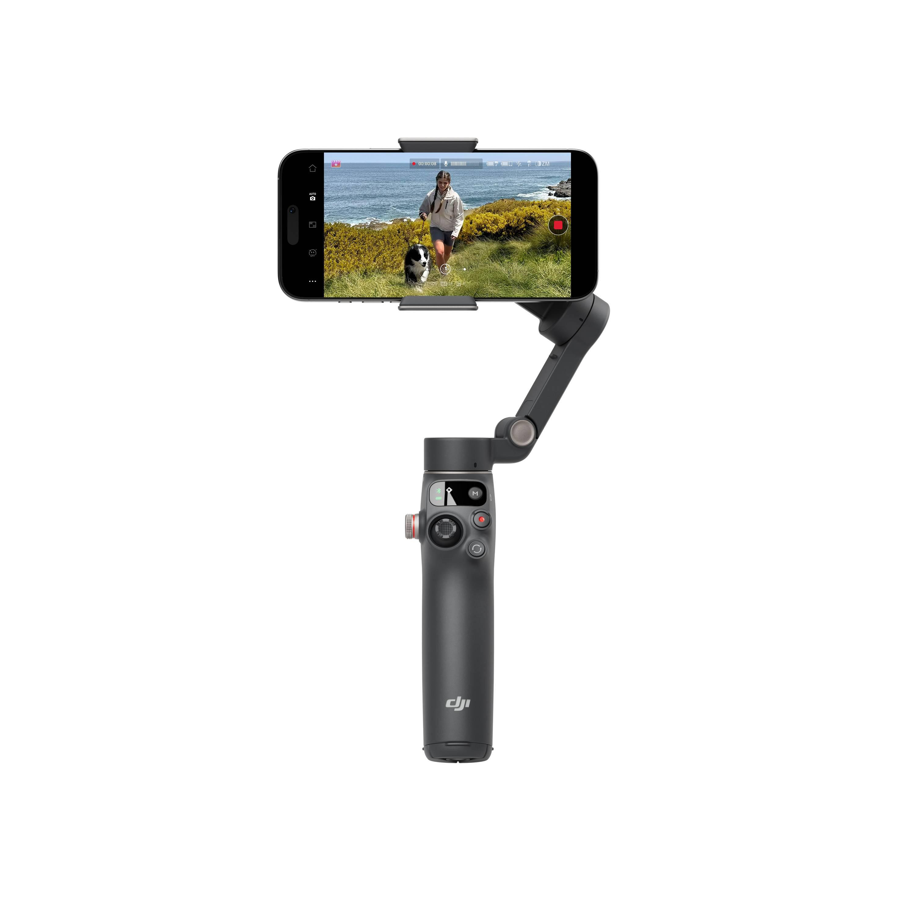 Ein Gimbal hält ein Smartphone, auf dem eine Frau und ein Hund am Meer zu sehen sind.