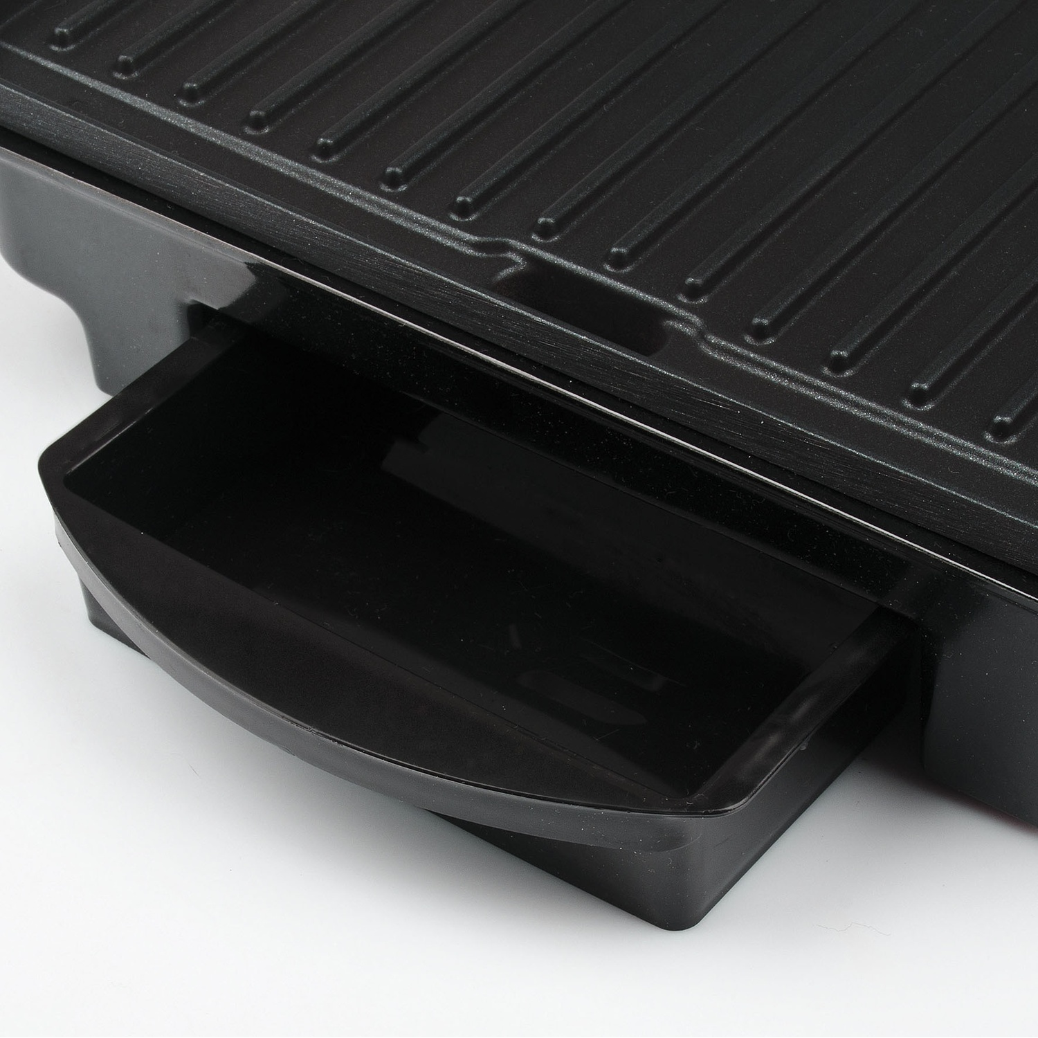 Primo piano di una piastra grill nera con vaschetta raccogligocce.