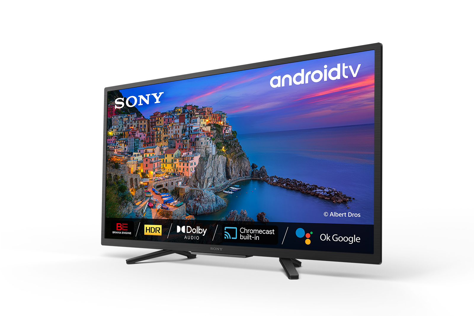 Telewizor Sony Android wyświetla obraz nadmorskiego miasta o zachodzie słońca.