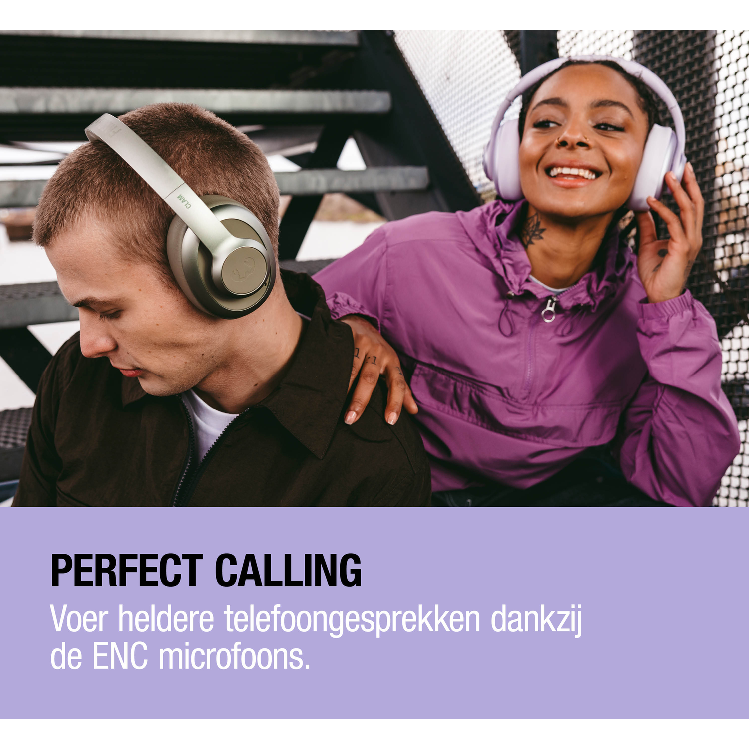 A man wearing headphones sits next to a smiling woman wearing headphones.