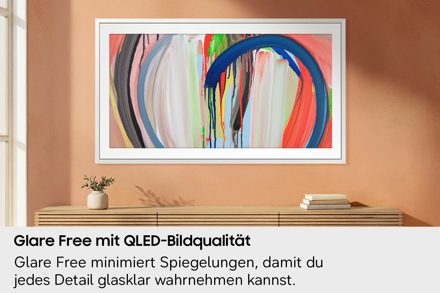 Ein moderner Fernseher mit abstraktem Bild hängt über einem Holzsideboard mit Deko.
