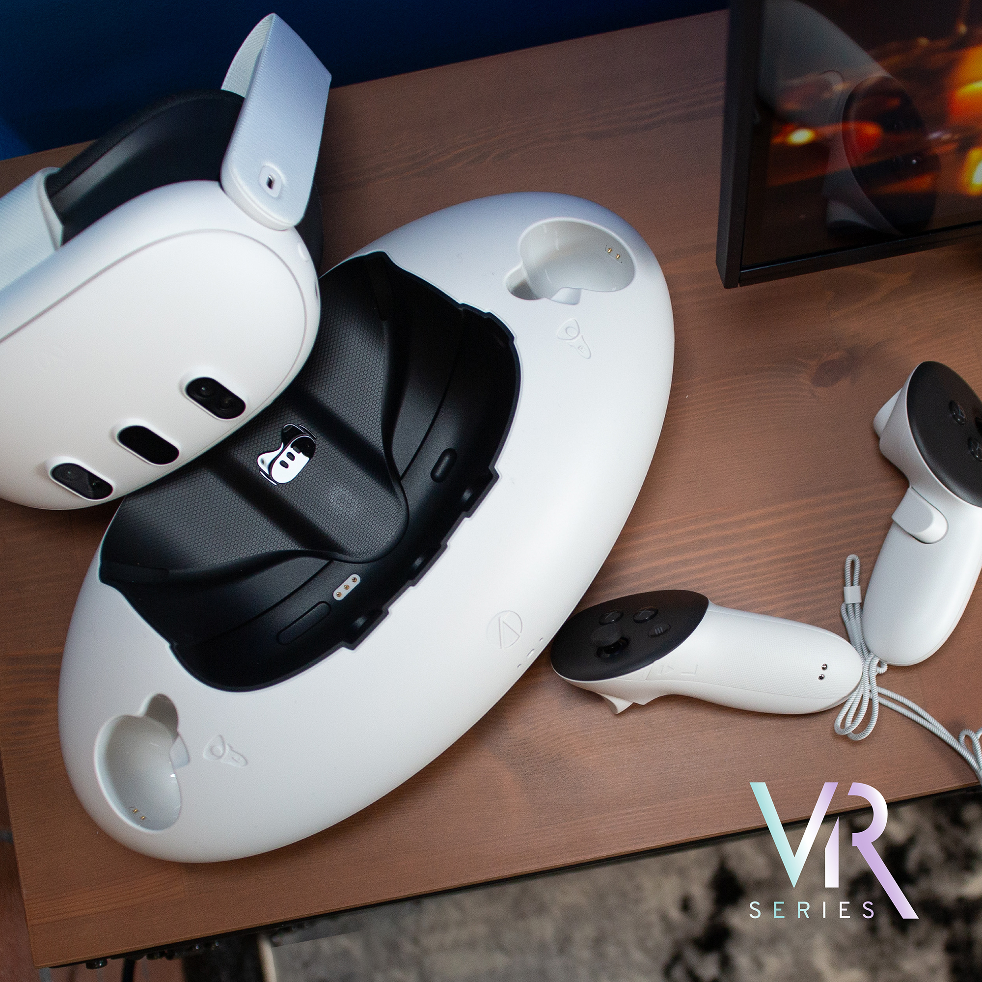 Ein weißes VR-Headset und Controller liegen auf einem Holztisch neben einer Ladestation.
