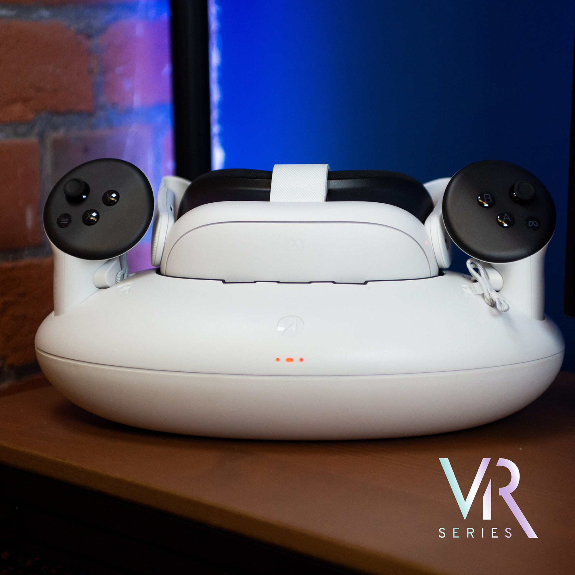 Ein weißes VR-Headset mit Controllern in einer Ladestation. Hintergrund ist unscharf.