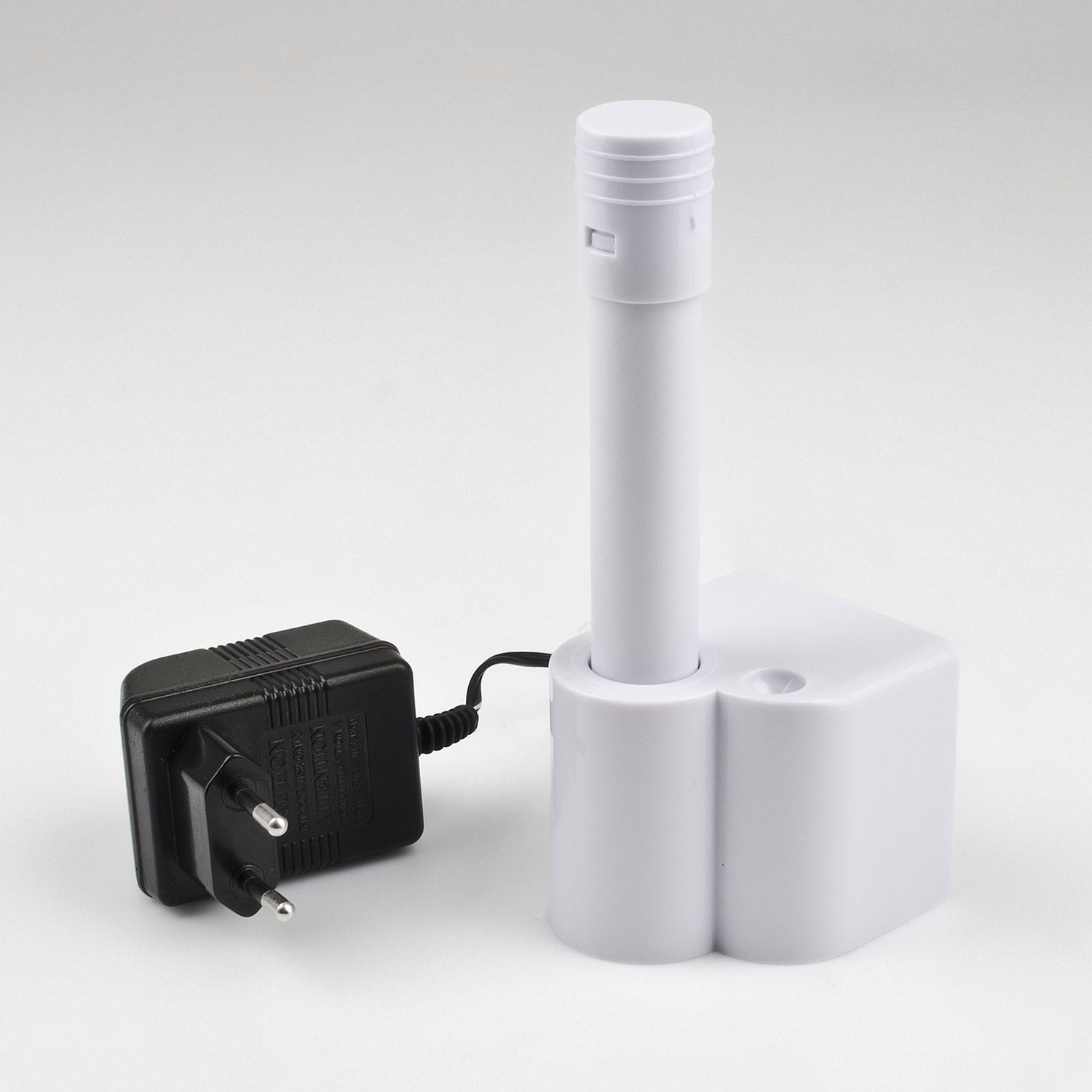 Un adattatore di ricarica bianco con spina nera e accessorio bianco.