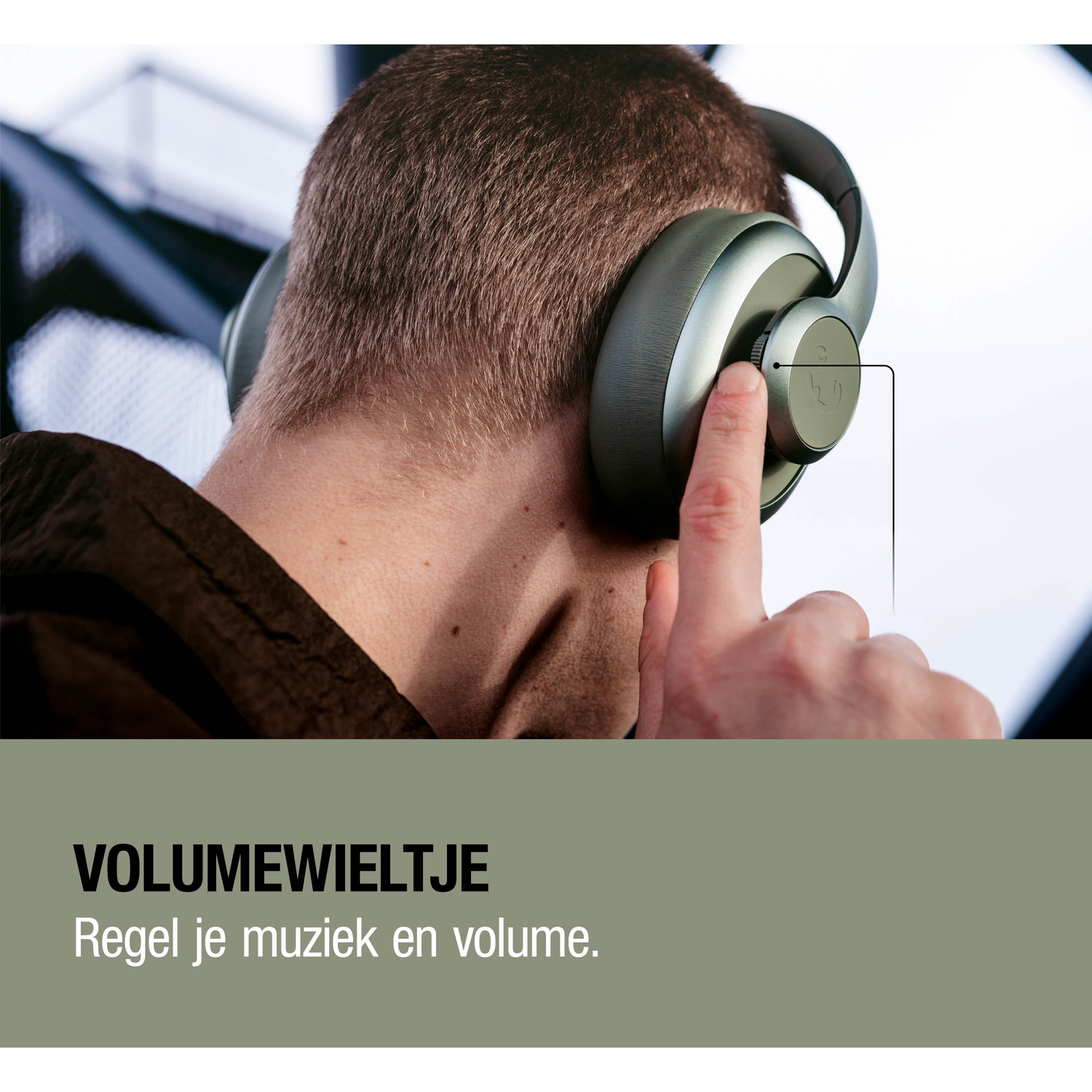 Man wearing headphones, turning a volume control wheel.