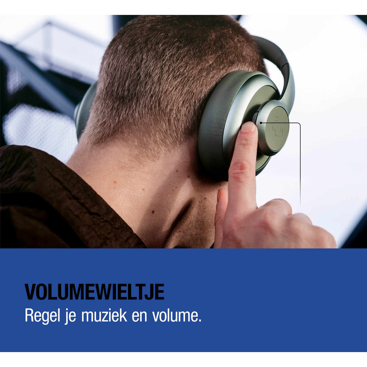 A man wearing headphones adjusts the volume dial.