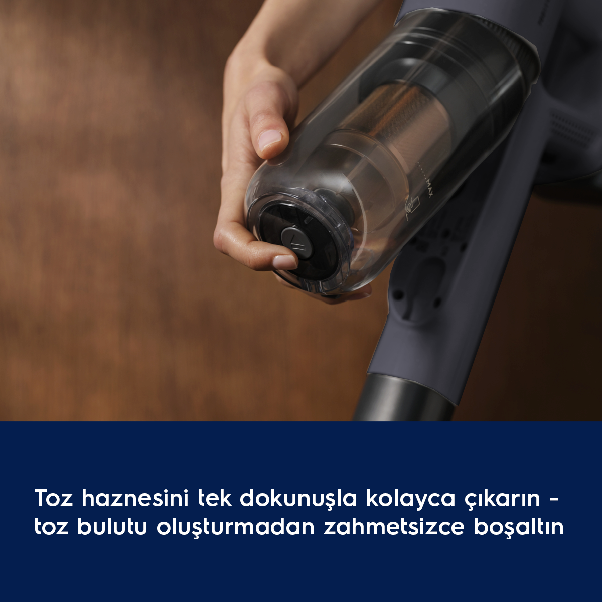 Bir el, bir elektrikli süpürgenin şeffaf toz haznesini tutuyor.