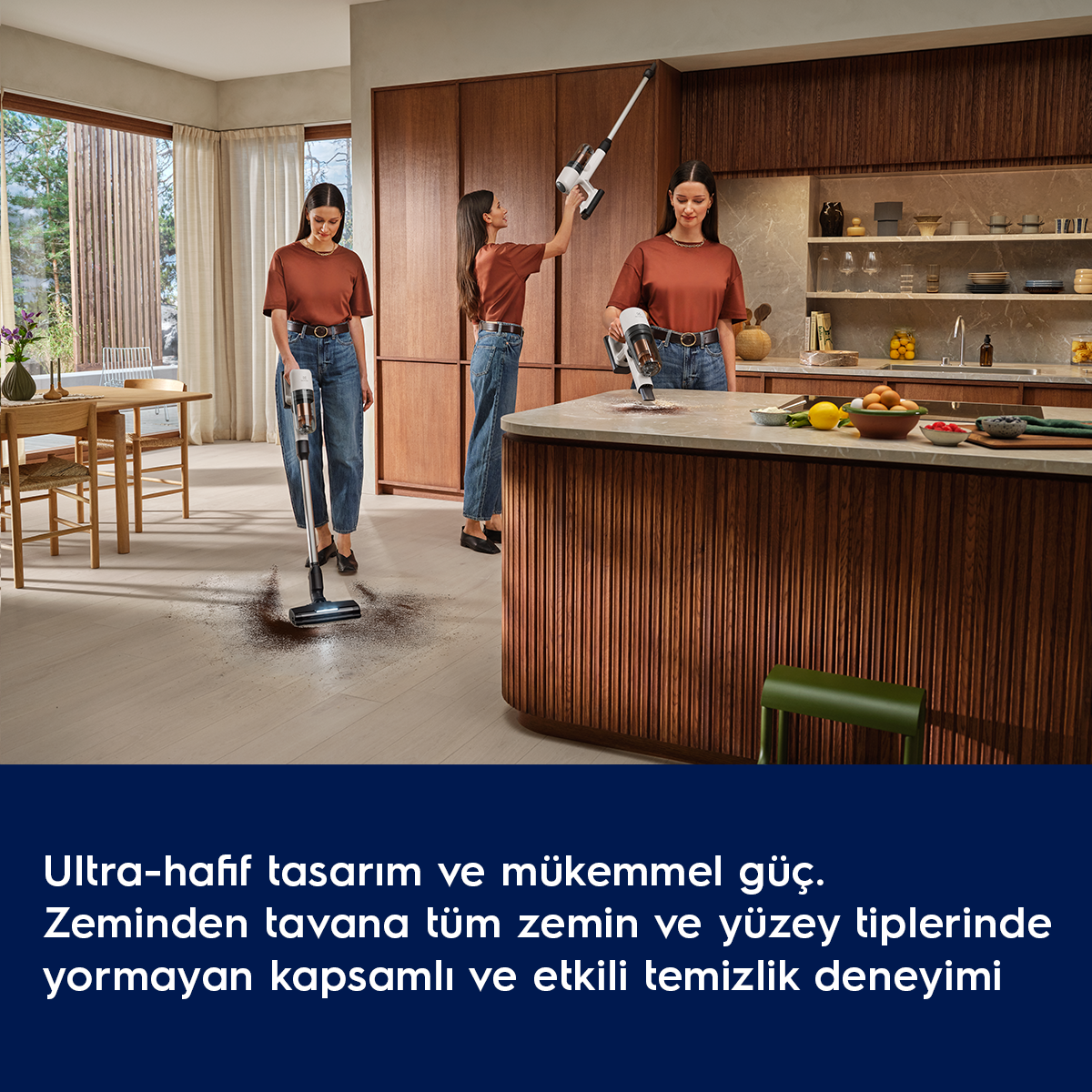 Üç kadın modern mutfakta hafif bir elektrikli süpürge kullanıyor.