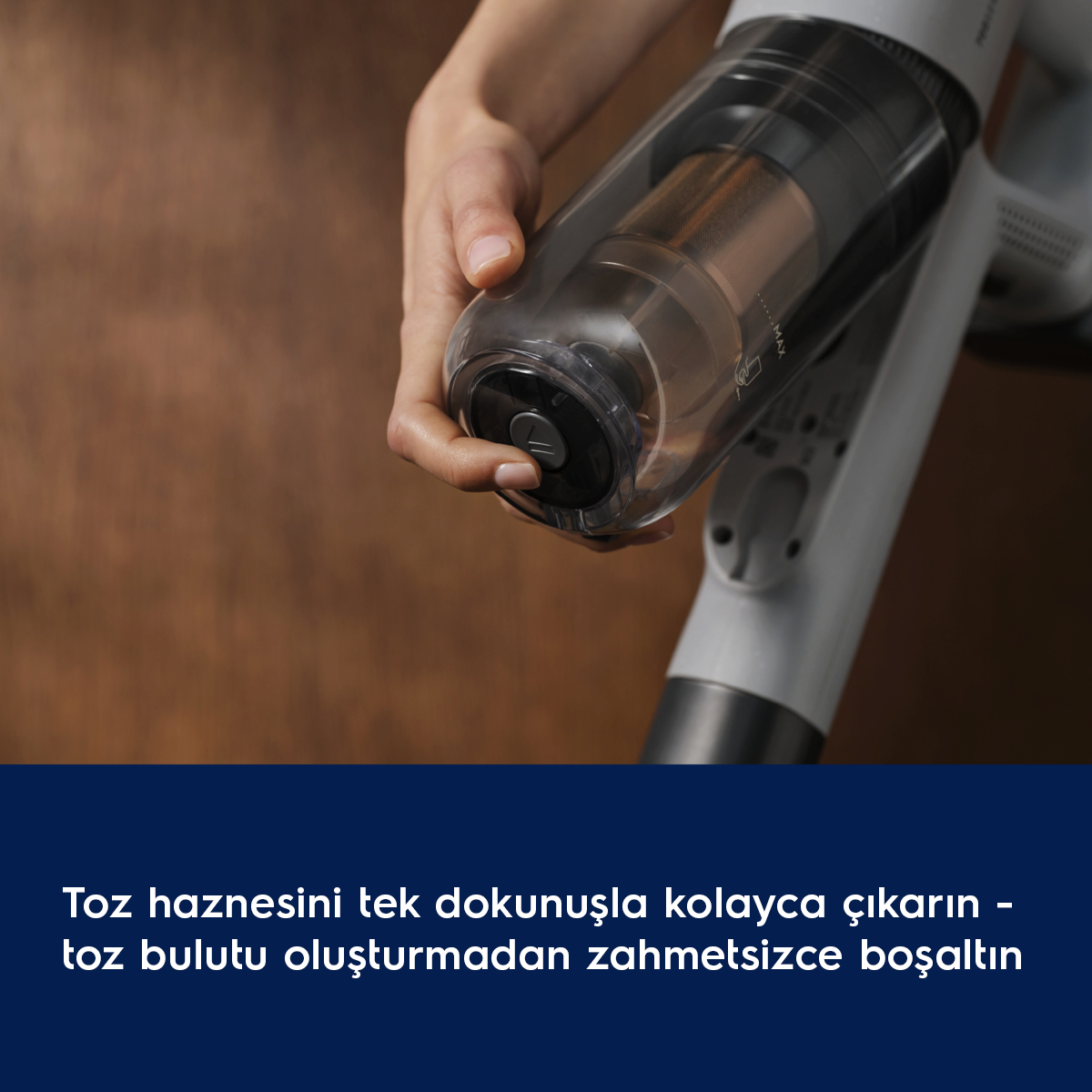Bir el, elektrikli süpürgenin şeffaf toz haznesini tutuyor.
