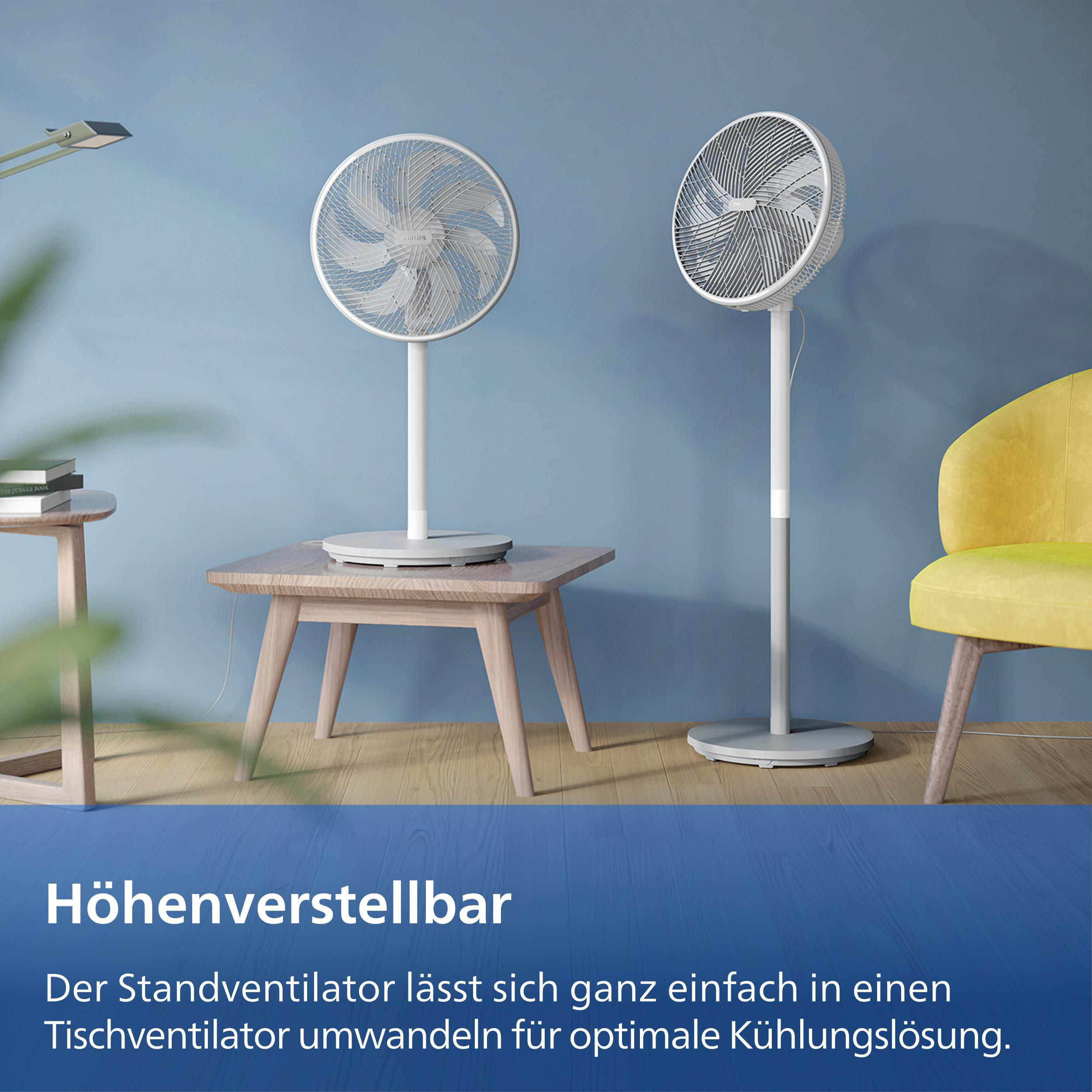 Zwei weiße Standventilatoren auf einem Holzboden vor blauer Wand.
