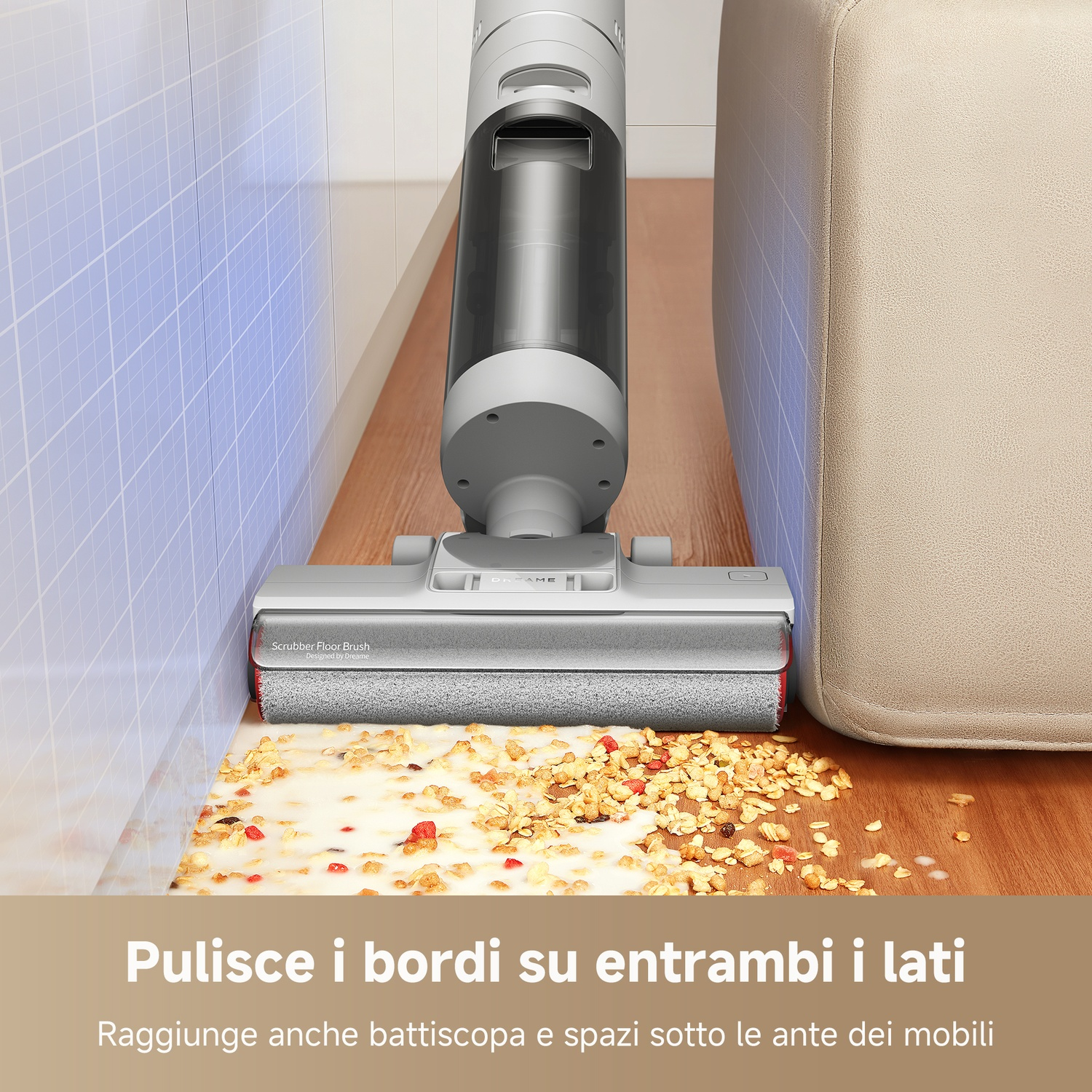 Un aspirapolvere pulisce cereali e liquidi vicino al bordo di un divano chiaro.