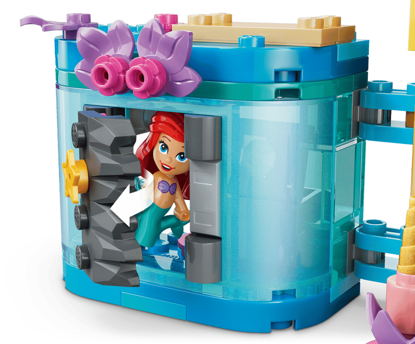 Ariel tritt aus einer felsartigen Tür in einer blauen, durchscheinenden Lego-Struktur.