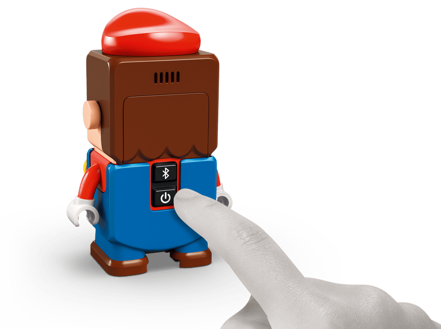 Ein Finger drückt auf den Ein-/Ausschalter eines Mario-Spielzeugs.