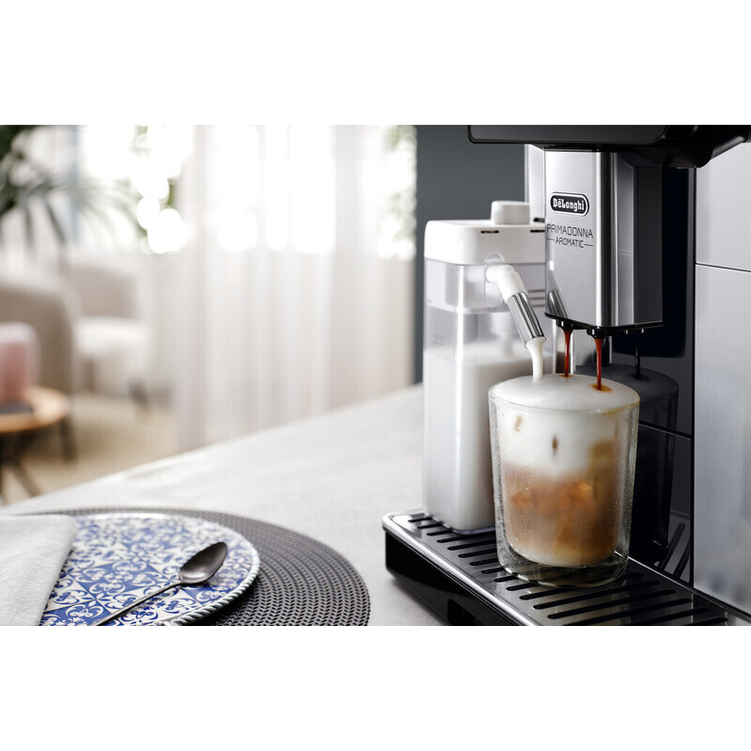 A coffee machine brews an iced coffee with lots of foam into a glass.