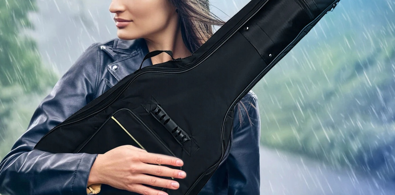 Kobieta w deszczu niesie czarną torbę na gitarę.