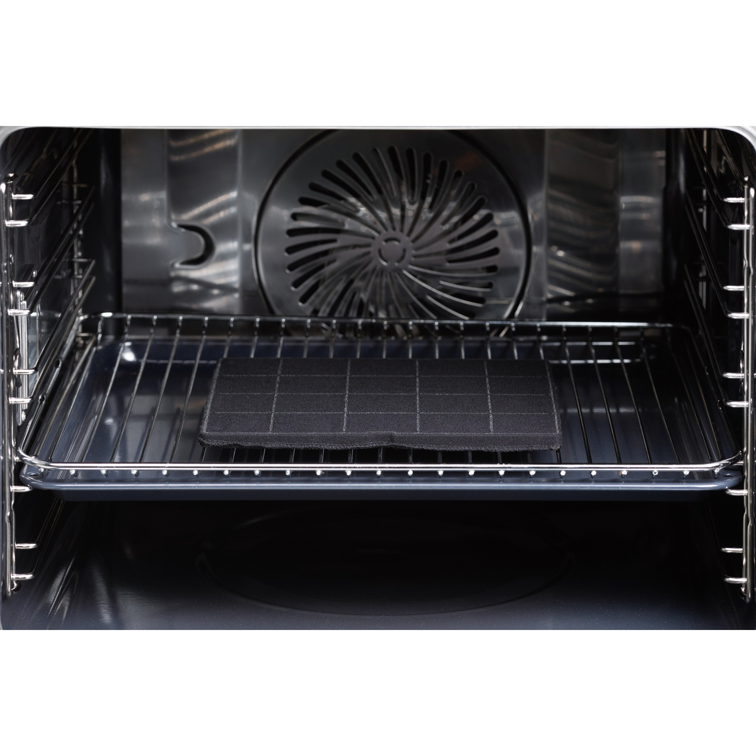 Inside view of a clean oven with a black charcoal filter on the middle rack.