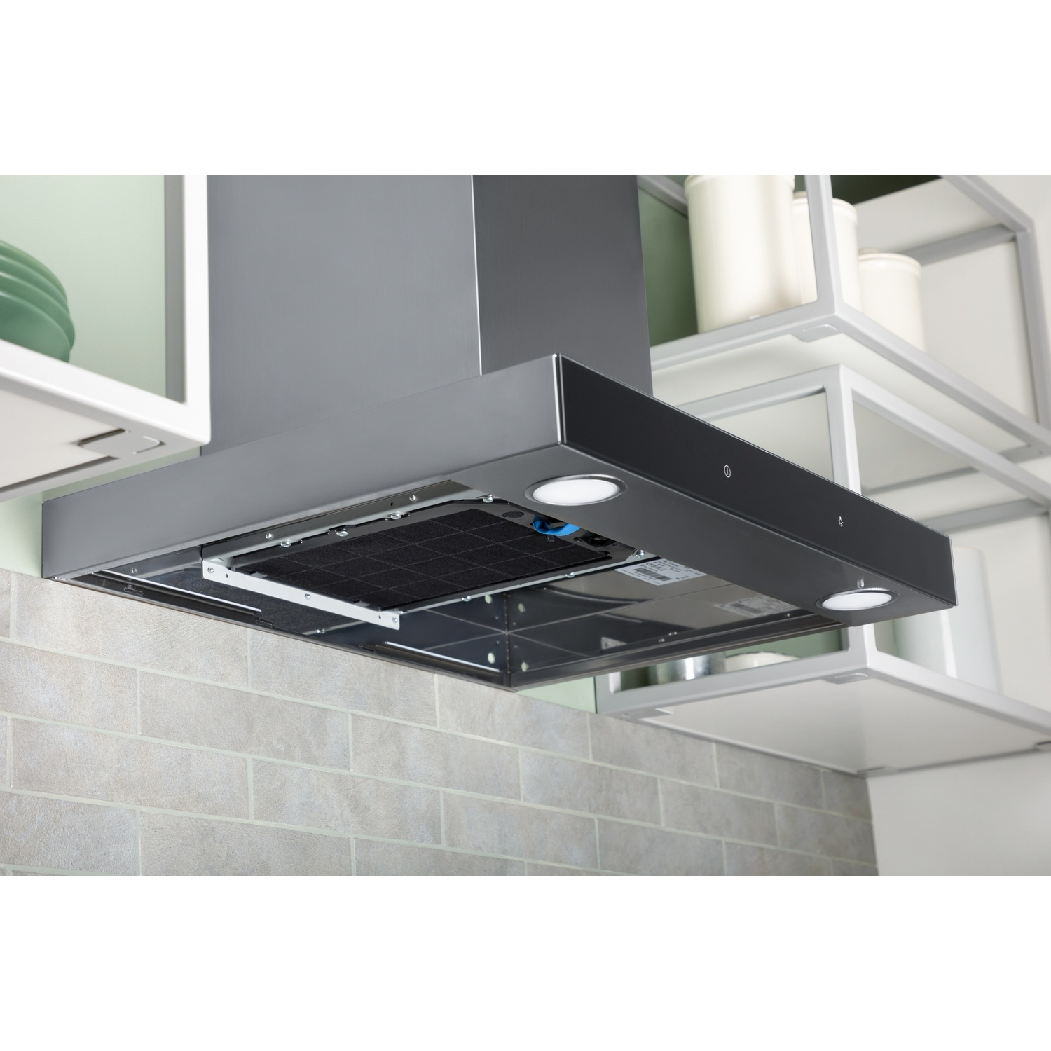 Stainless steel range hood with charcoal filter and lights above a tiled wall.