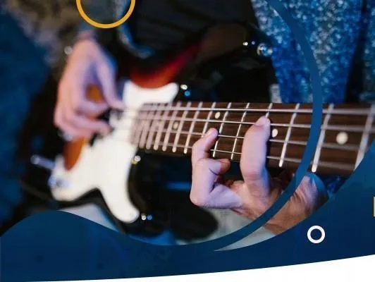 Zbliżenie dłoni grających na gitarze elektrycznej z białymi i brązowymi detalami.