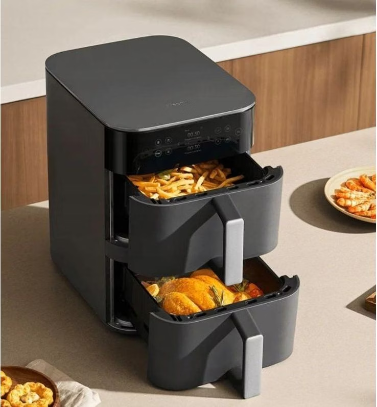 Egy fekete légkeveréses fritő két fiókkal. Fent sültkrumpli, lent csirke.