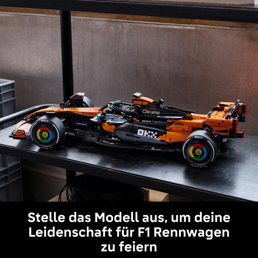 Ein Lego-Modell eines orangefarbenen McLaren F1-Rennwagens steht auf einem Regal.