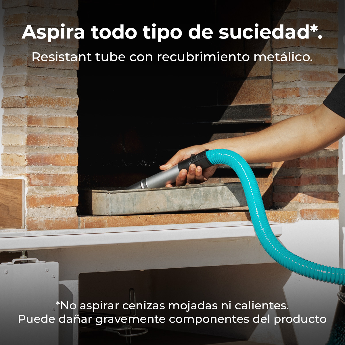 Una mano aspira una chimenea con una manguera con recubrimiento metálico.