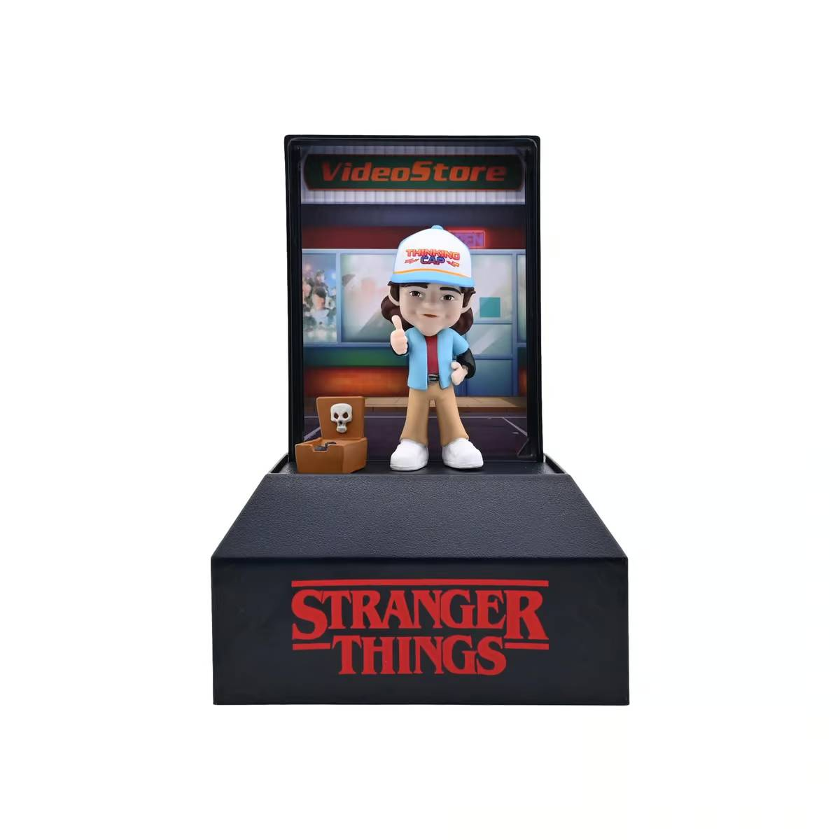 Figura de "Stranger Things" de un niño con gorra "Thinking Cap" y fondo de "VideoStore".