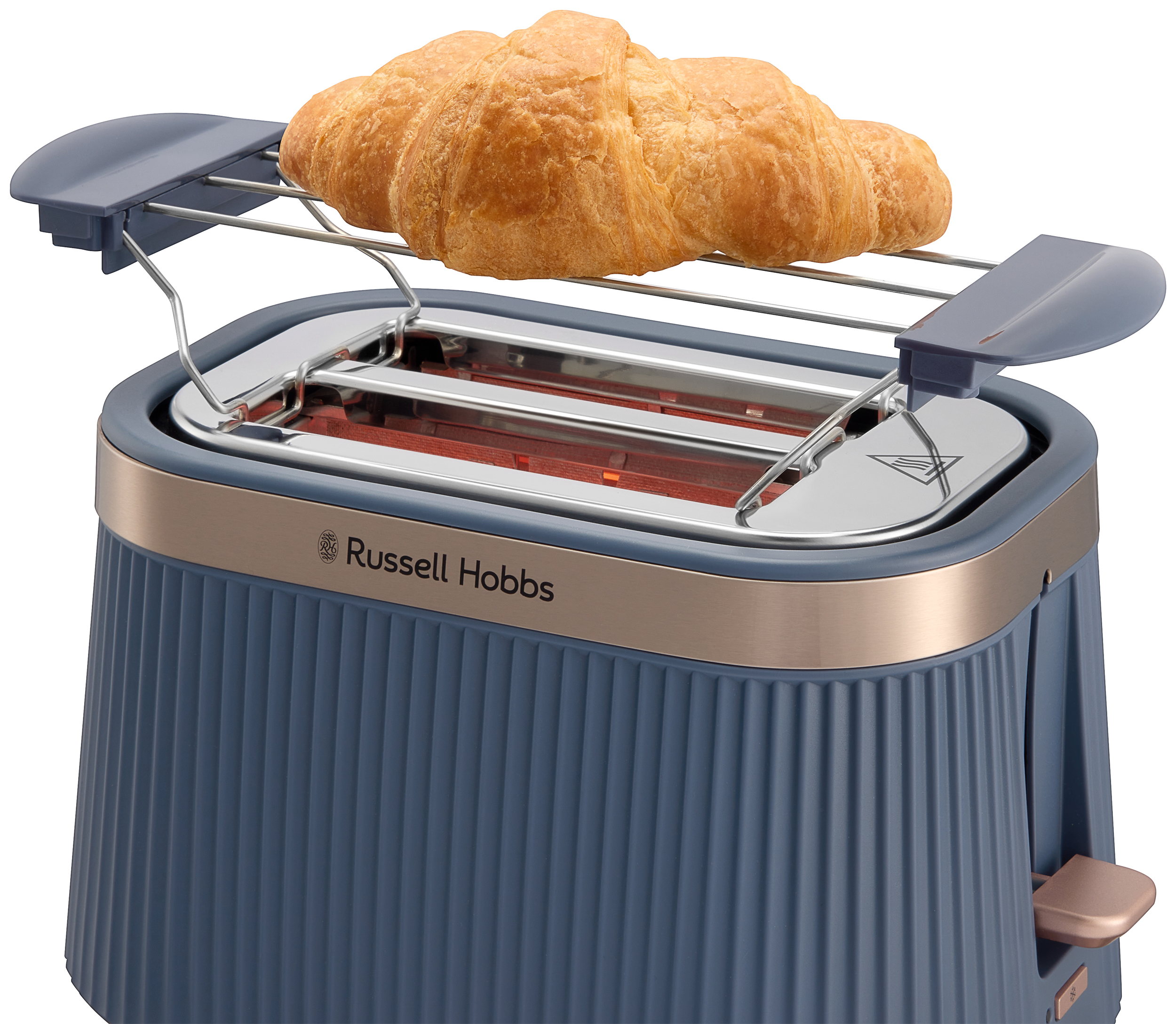 Kék kenyérpirító arany szegéllyel, és croissant a melegítő rácson.
