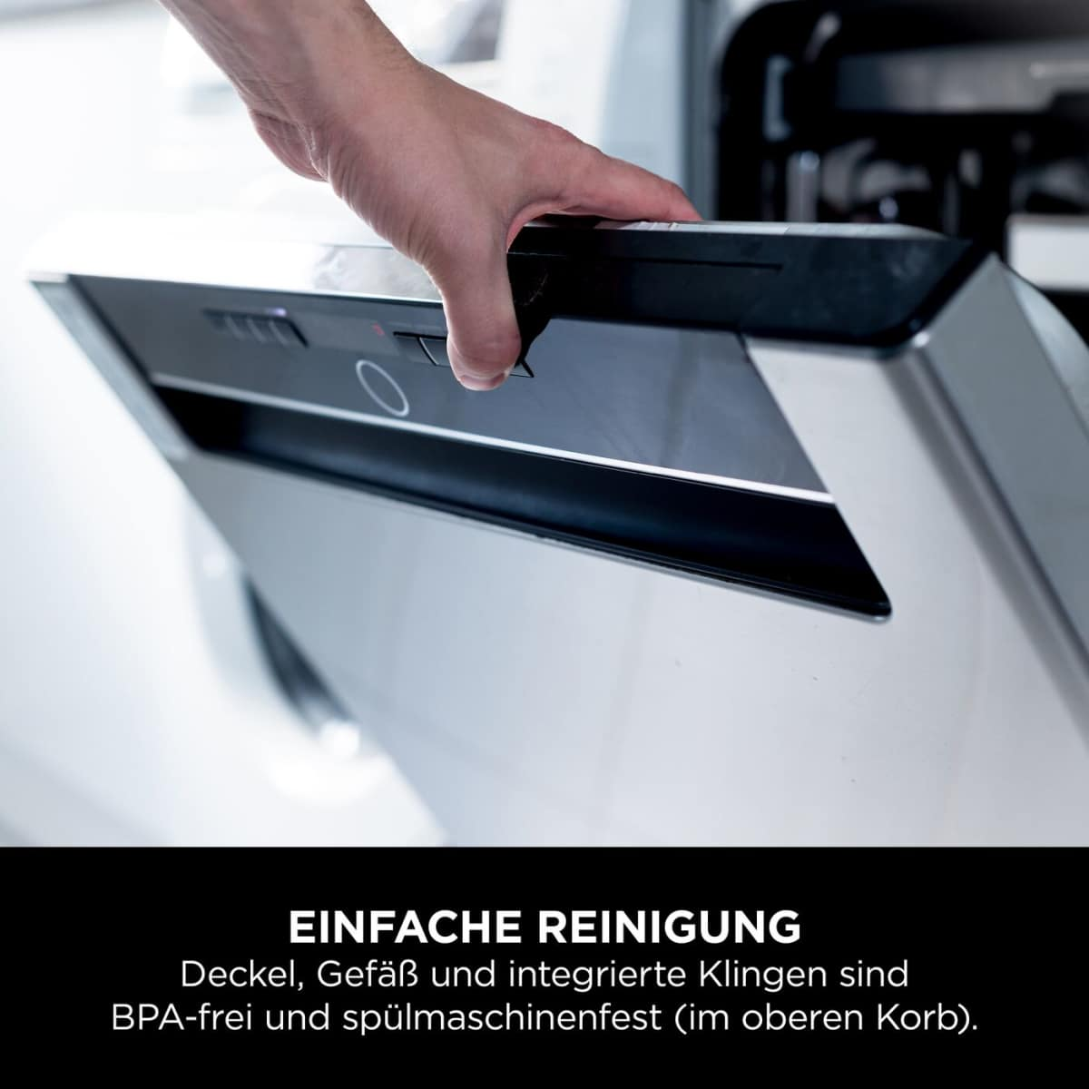 Hand öffnet eine Spülmaschine. Der Deckel ist aus Metall und Kunststoff.