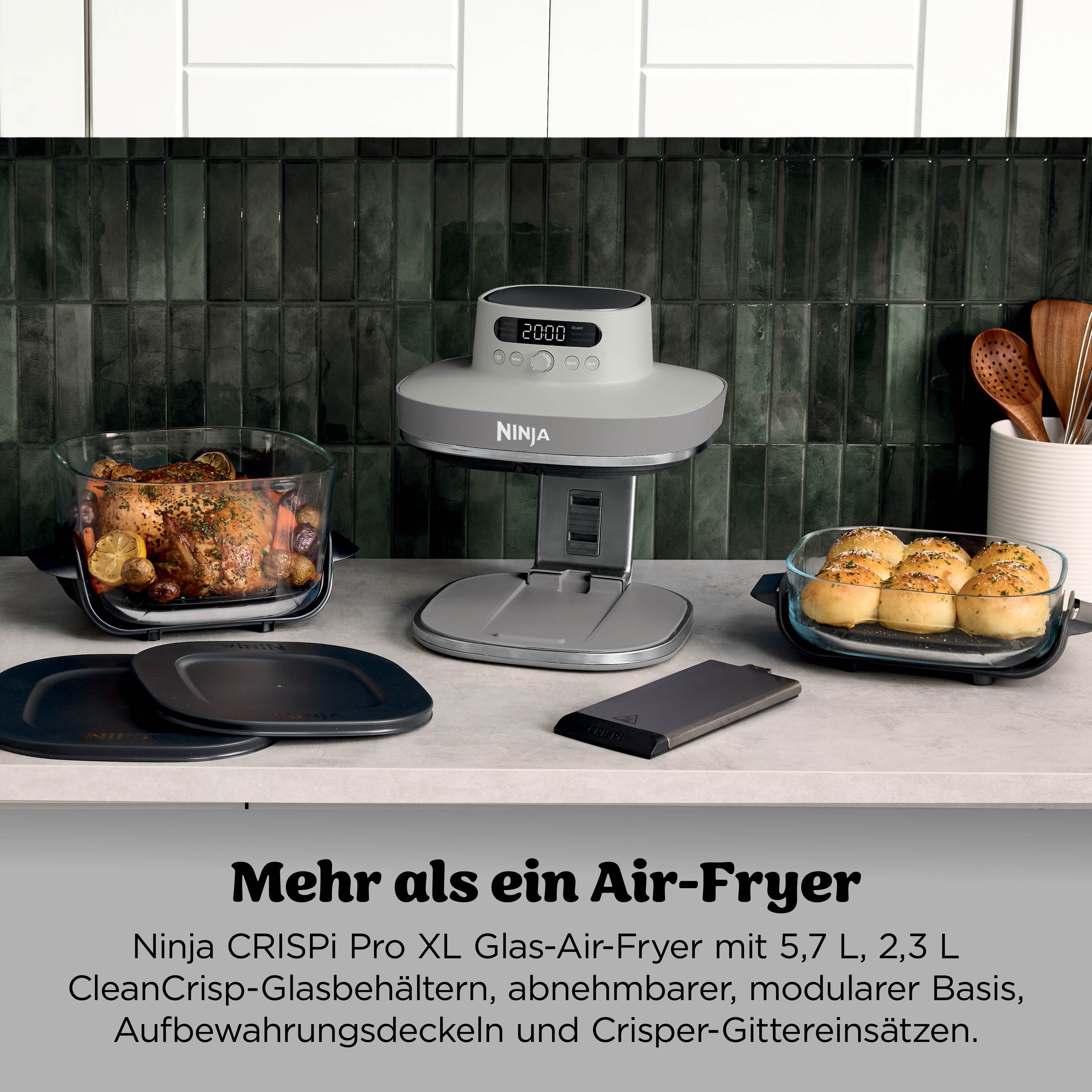 Ein Ninja Air-Fryer mit gebratenem Huhn und Brötchen, auf einer Arbeitsplatte.