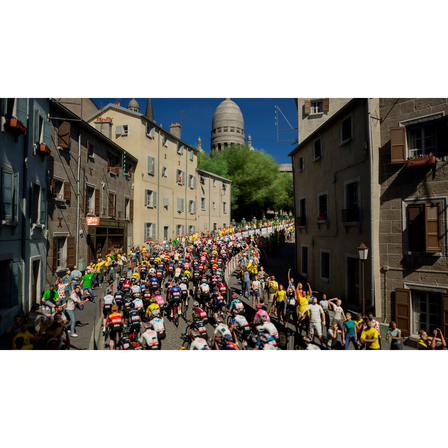 Cyclists race through a city lined with spectators on the streets.