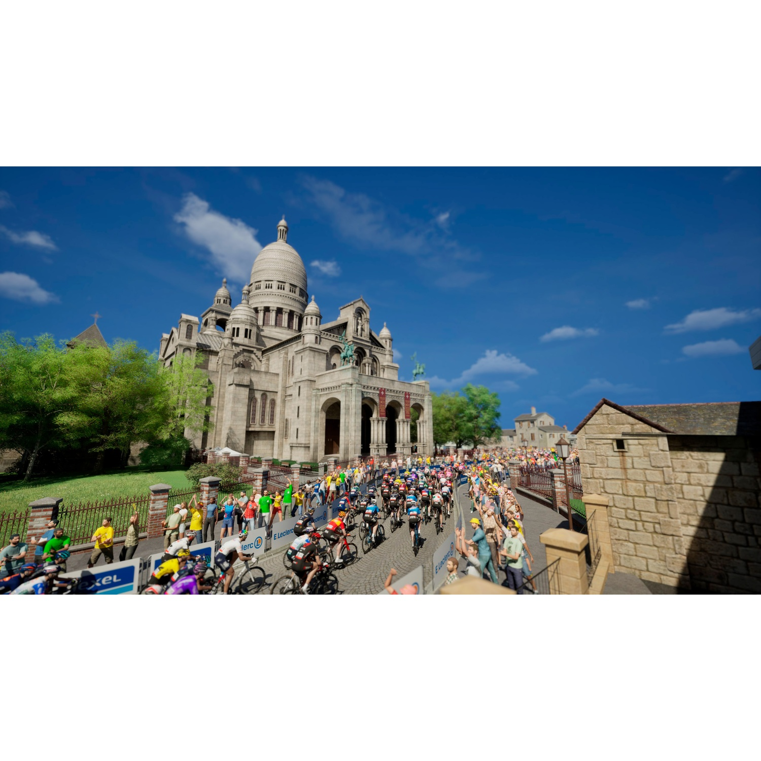 Cyclists race past Sacré-Cœur Basilica, spectators line the street.