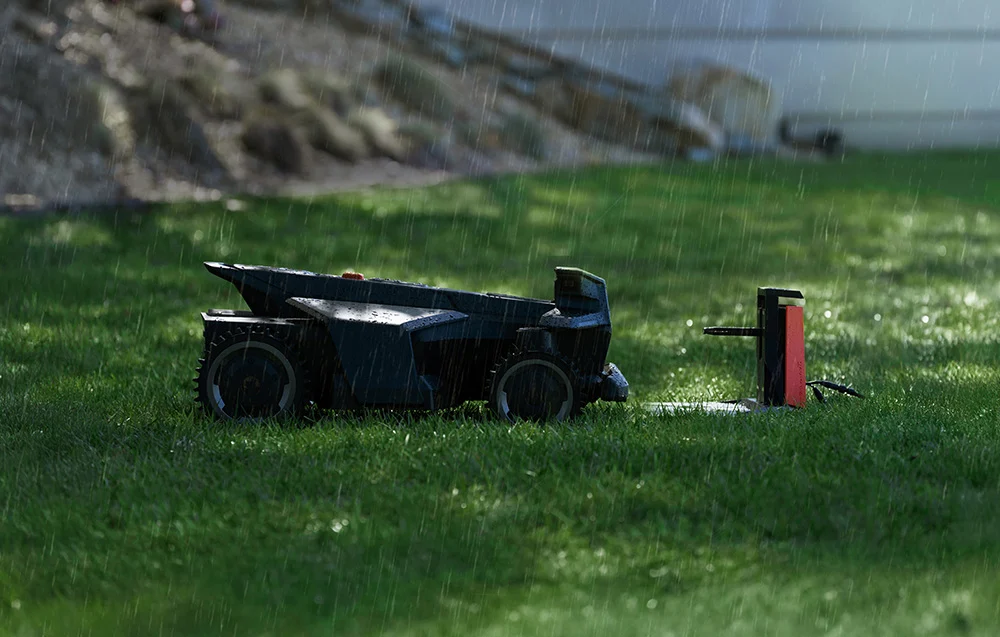 Egy robotfűnyíró esőben nedves füvön, mellette töltőállomás.