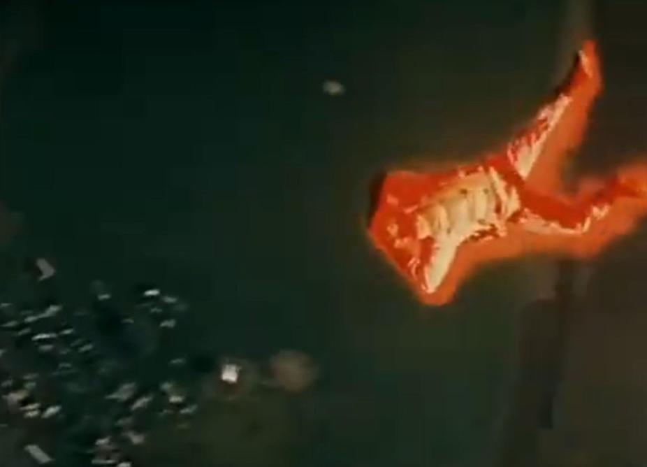 Orangefarbene Form brennt hell vor dunklem Hintergrund.